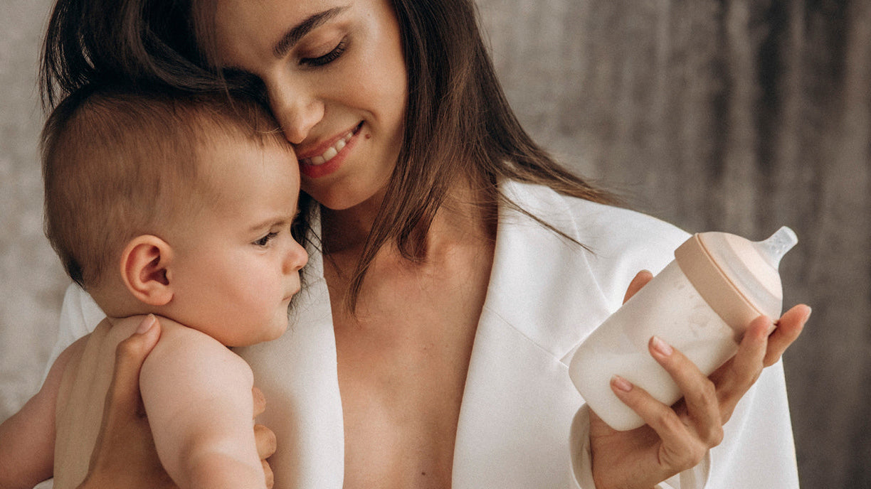 Maman tenant son bébé avec un biberon prêt pour une sortie