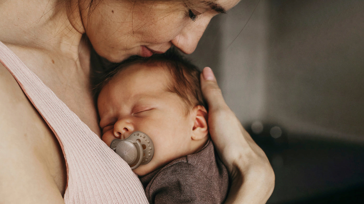 Maman embrassant tendrement son nouveau-né.