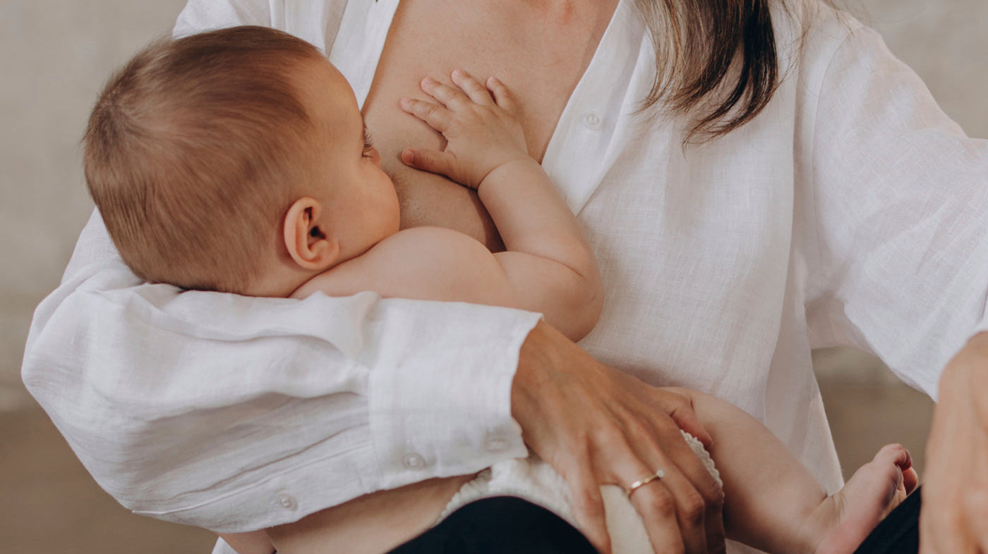 Bébé tétant au sein de sa mère, illustrant le lien affectif et l’allaitement maternel fréquent.
