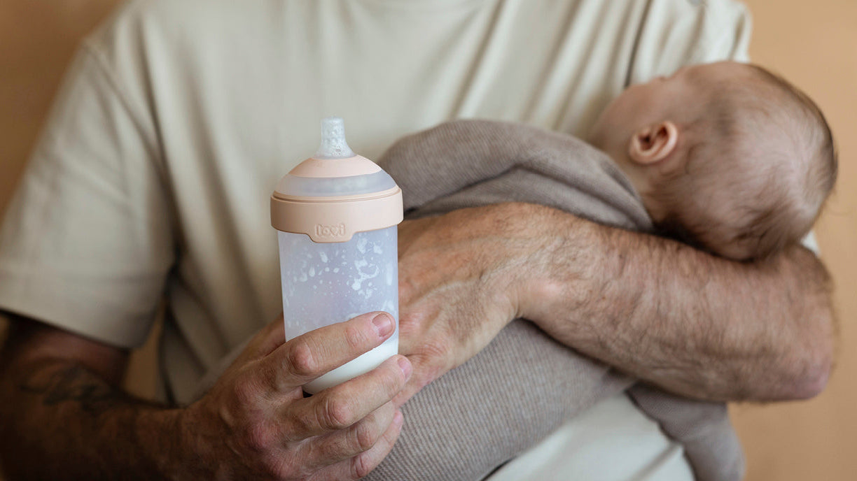 Parent tenant doucement un bébé agité et lui donnant le biberon Difrax MammaFeel pour un moment de tétée calme et confortable.
