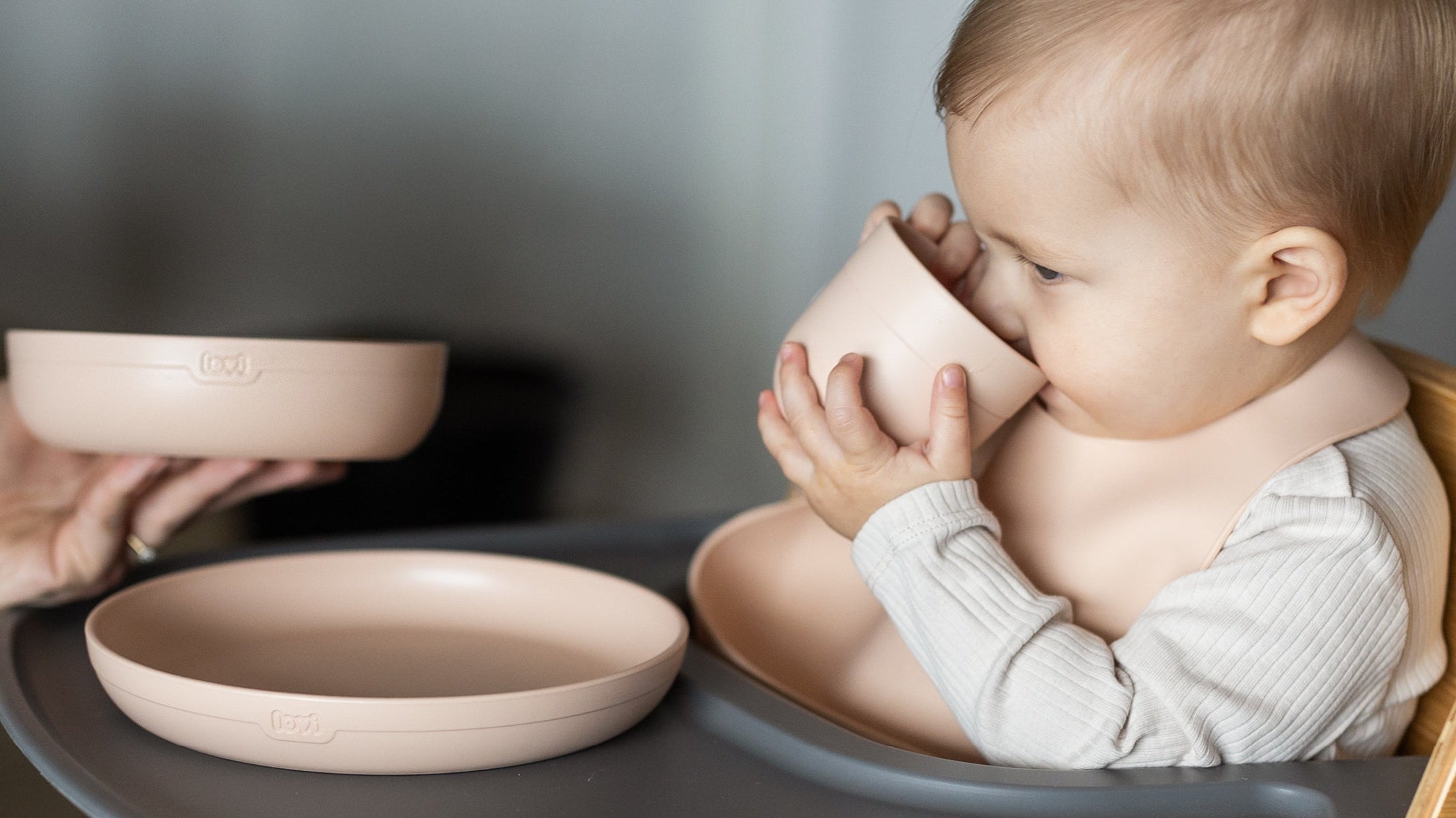 Bébé mange et boit avec le set repas Difrax Lovi, conçu pour faciliter l’alimentation et la transition vers le biberon.