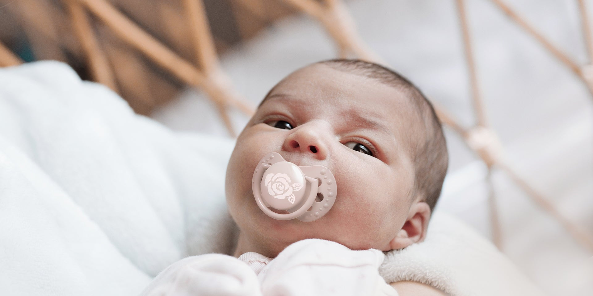 Un nouveau-né fille avec une sucette rose clair de la collection Difrax LOVI Baby Shower.