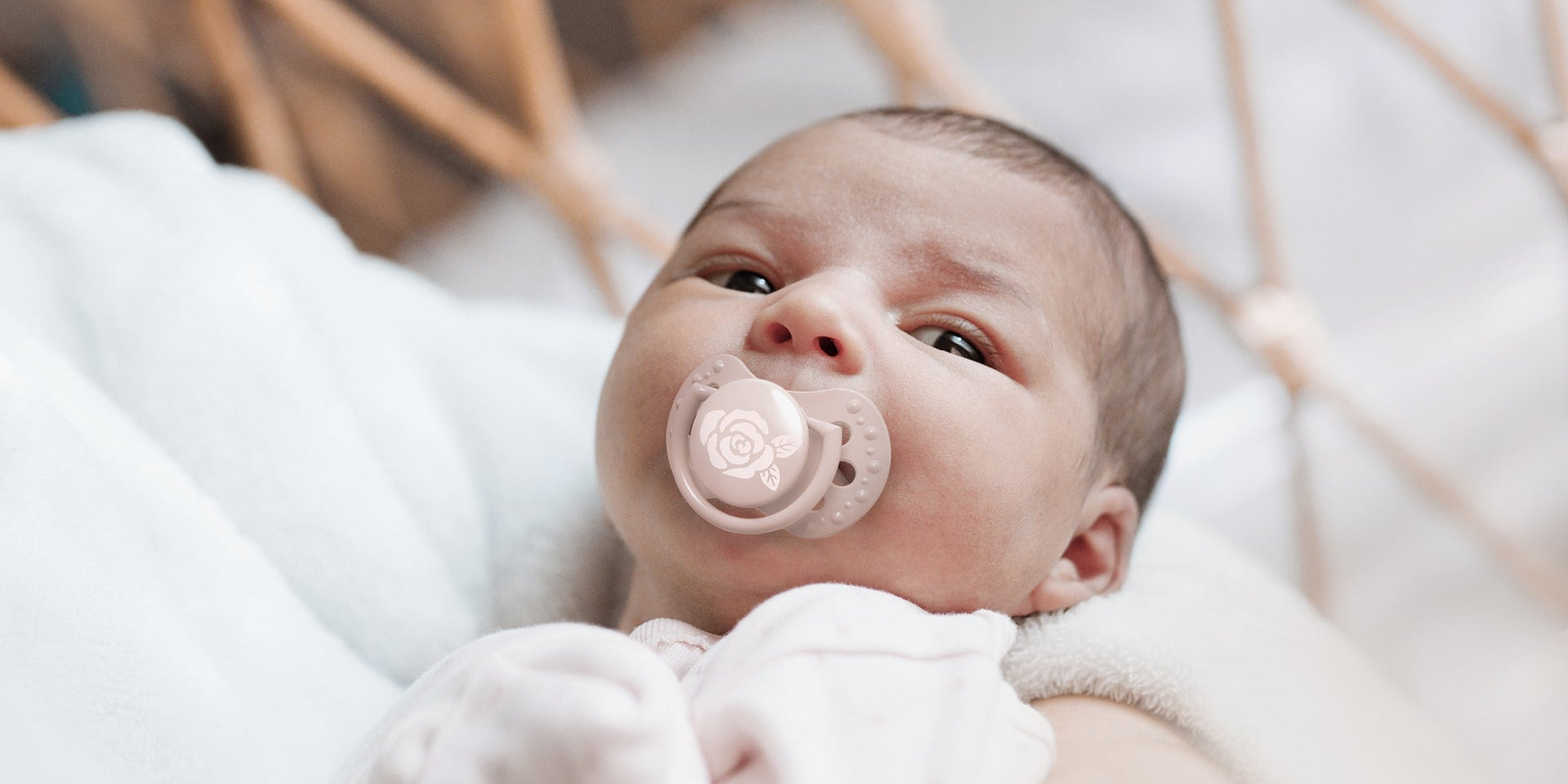 Un nouveau-né fille avec une sucette rose clair de la collection Difrax LOVI Baby Shower.