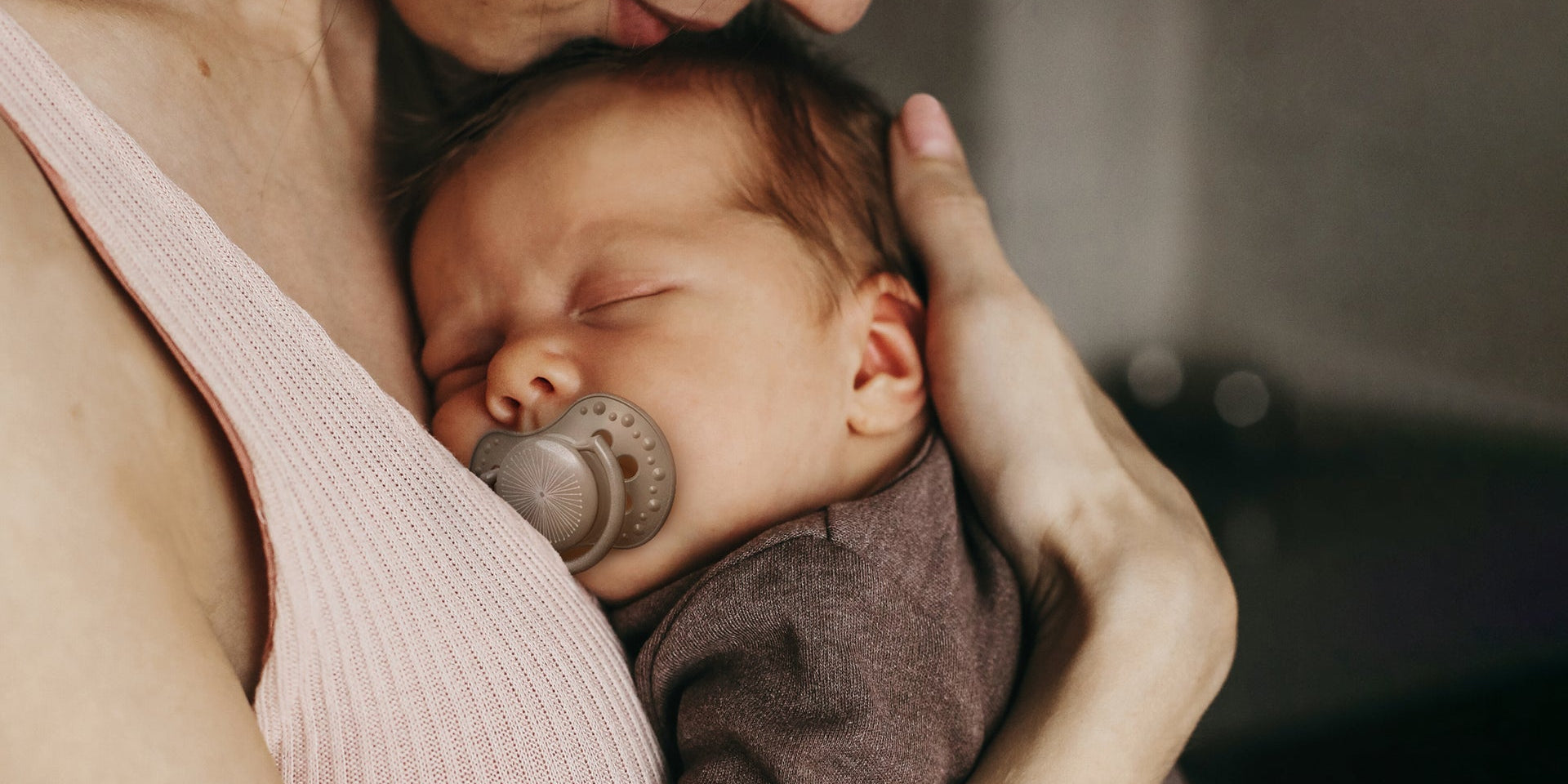 Un nouveau-né est allongé contre la poitrine de sa maman. Le bébé a une sucette Difrax LOVI pour nouveau-né.