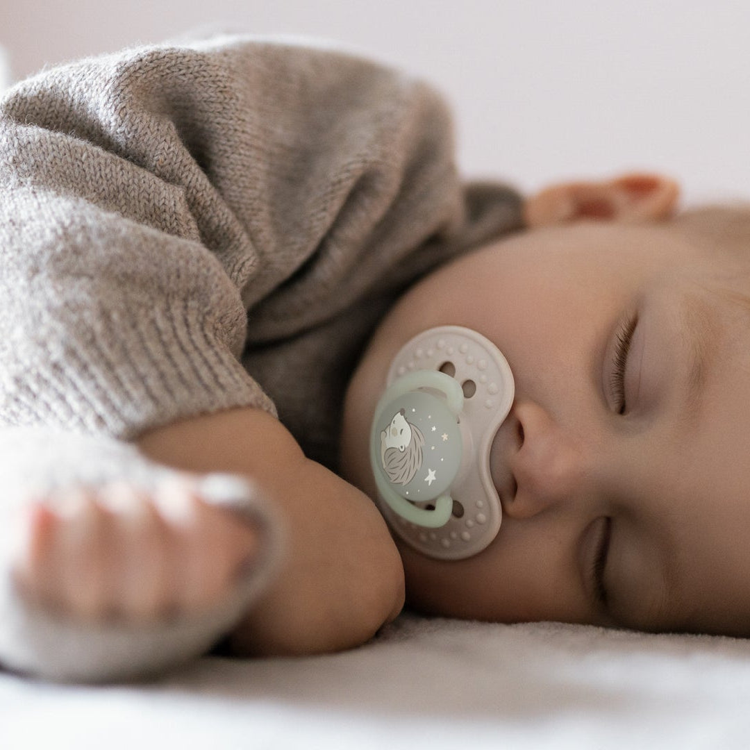 Un tout-petit dort dans son lit avec une sucette Difrax LOVI de la collection Night&Day.
