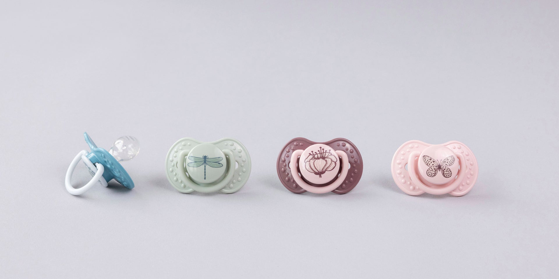 Une sucette bleue et verte sur une serviette. Les sucettes font partie de la collection Difrax LOVI Botanic.