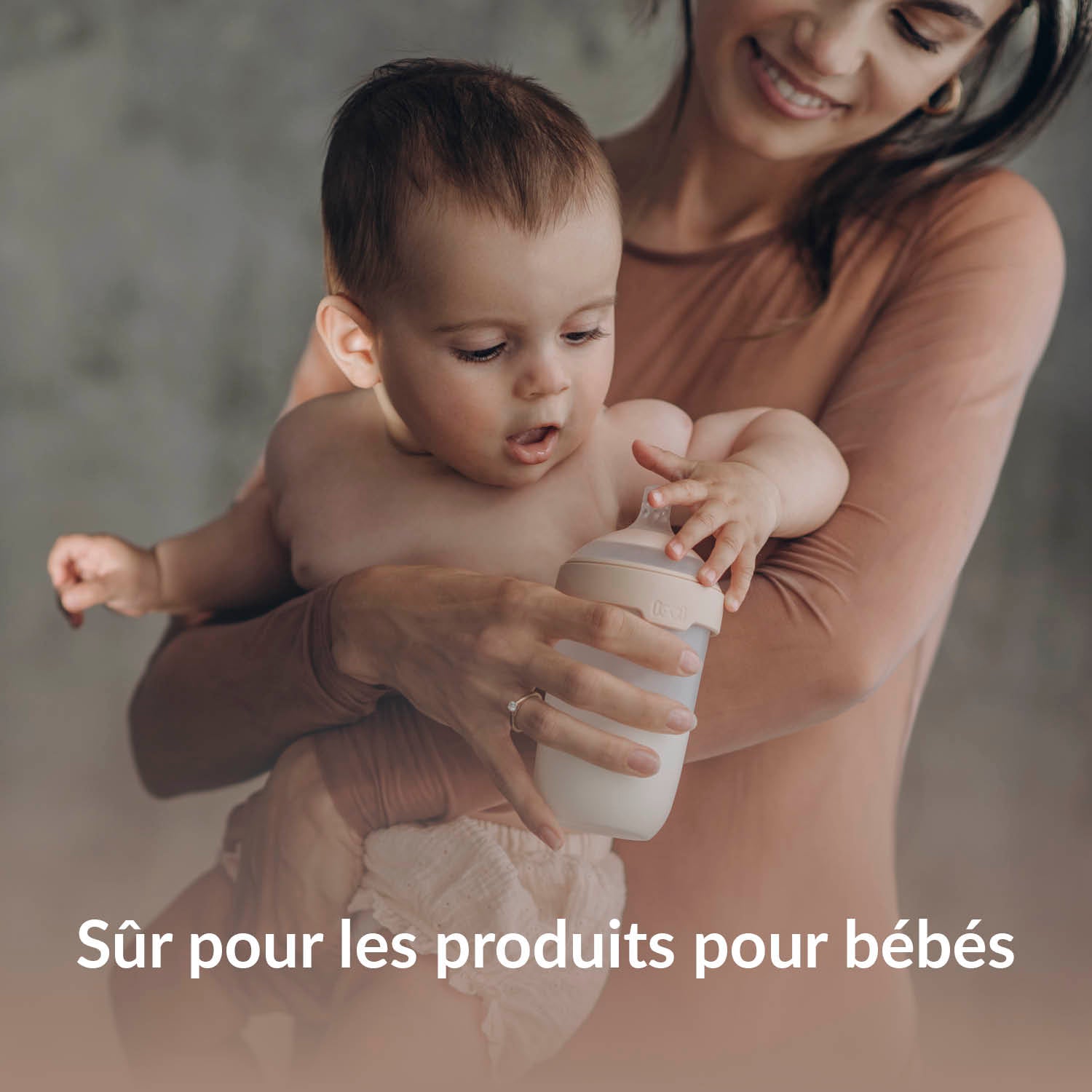 Mère souriante tenant son bébé avec un biberon Lovi – tablettes lave-vaisselle Difrax sûres pour le nettoyage des produits pour bébés