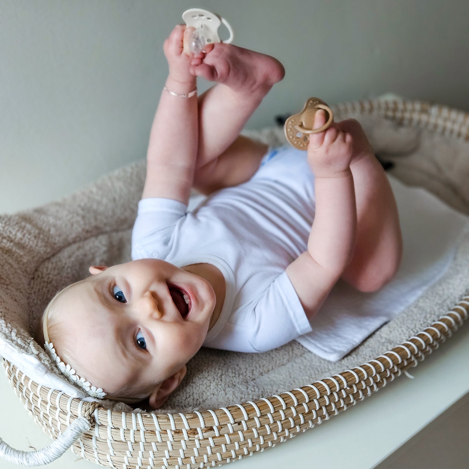 un bébé heureux qui joue avec des tétines crème et marron clair