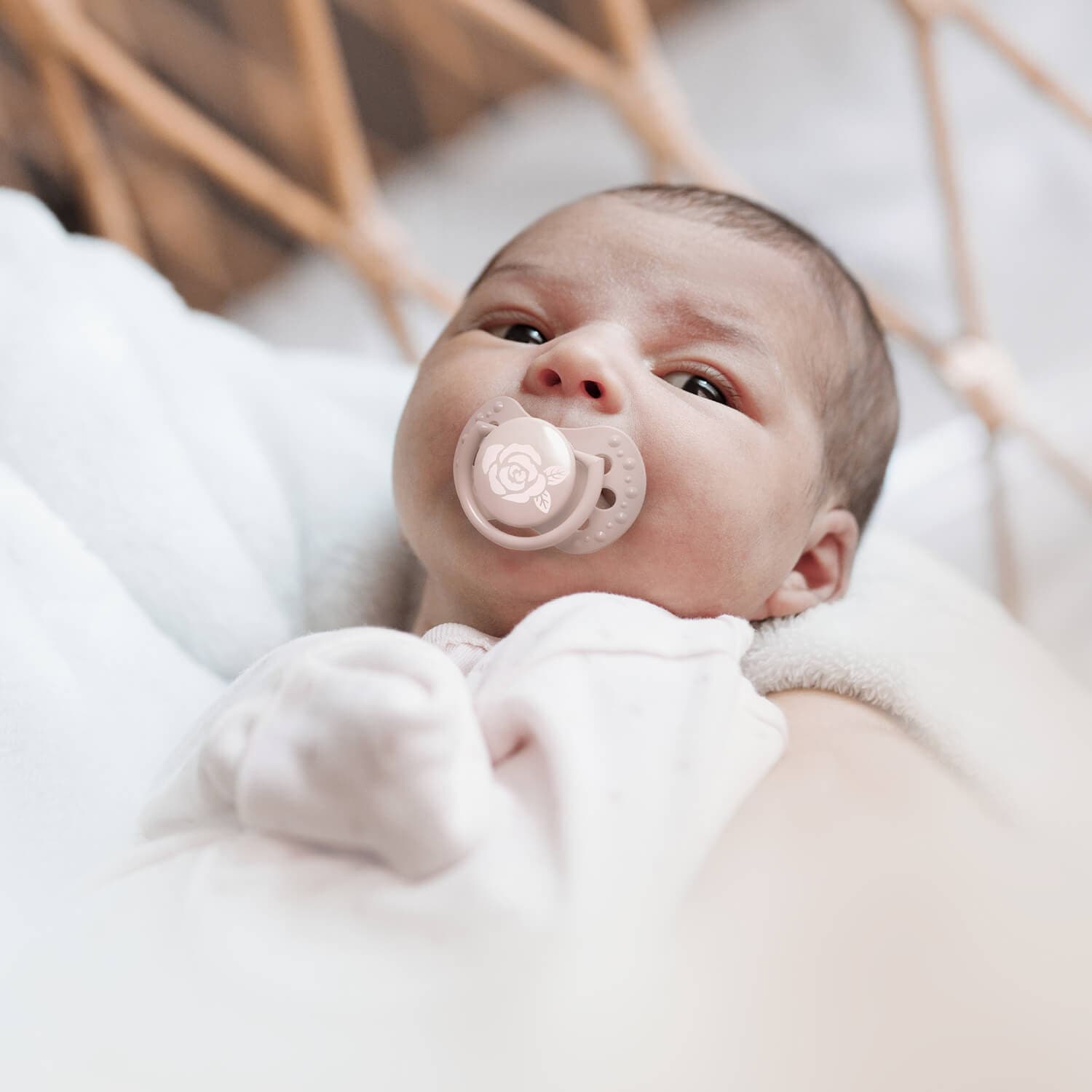 Bébé nouveau-né avec sucette rose Baby Shower allongé sur lit douille