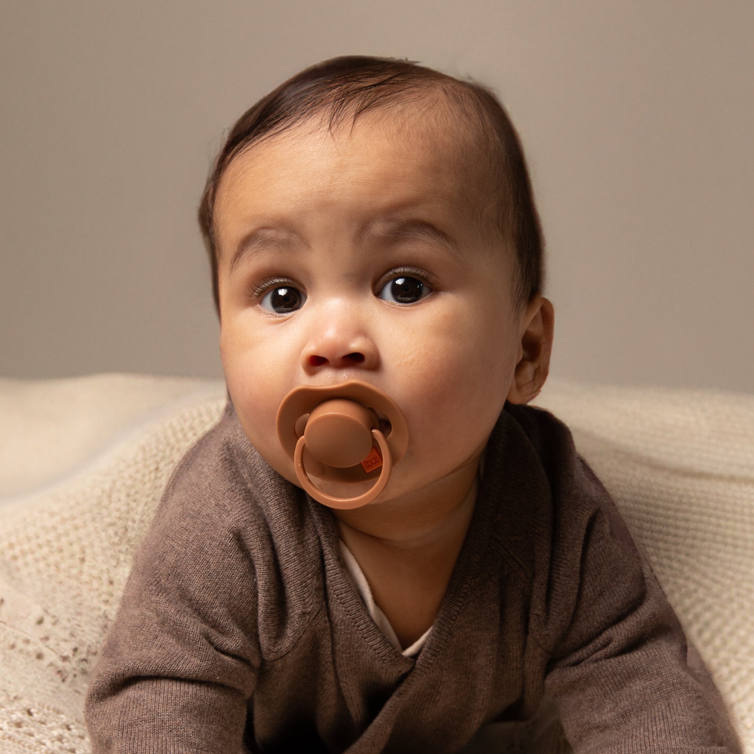 Un bébé couché avec le Dynamic Sucette Prime Granola