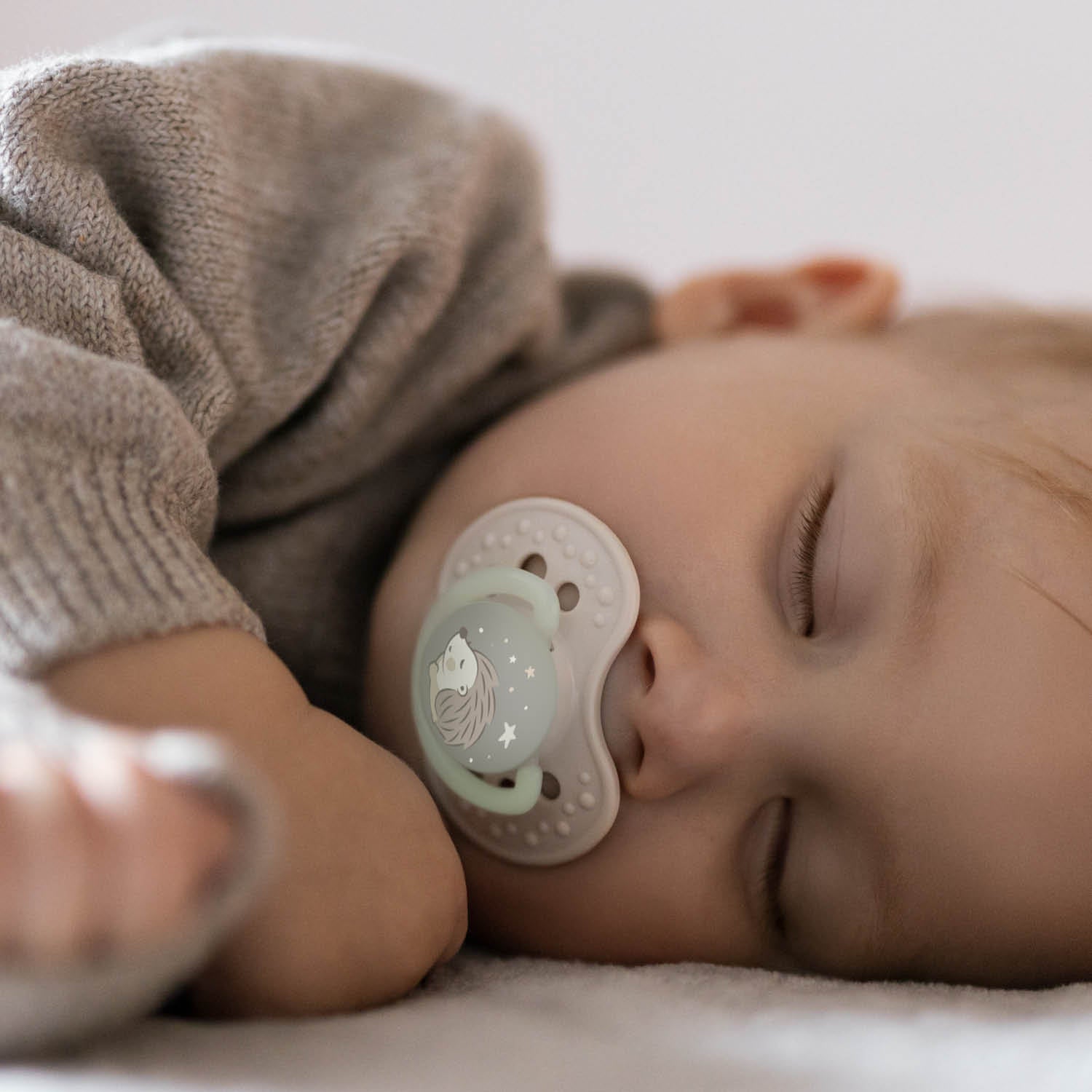 Un bébé qui dort avec sa sucette phosphorescente.
