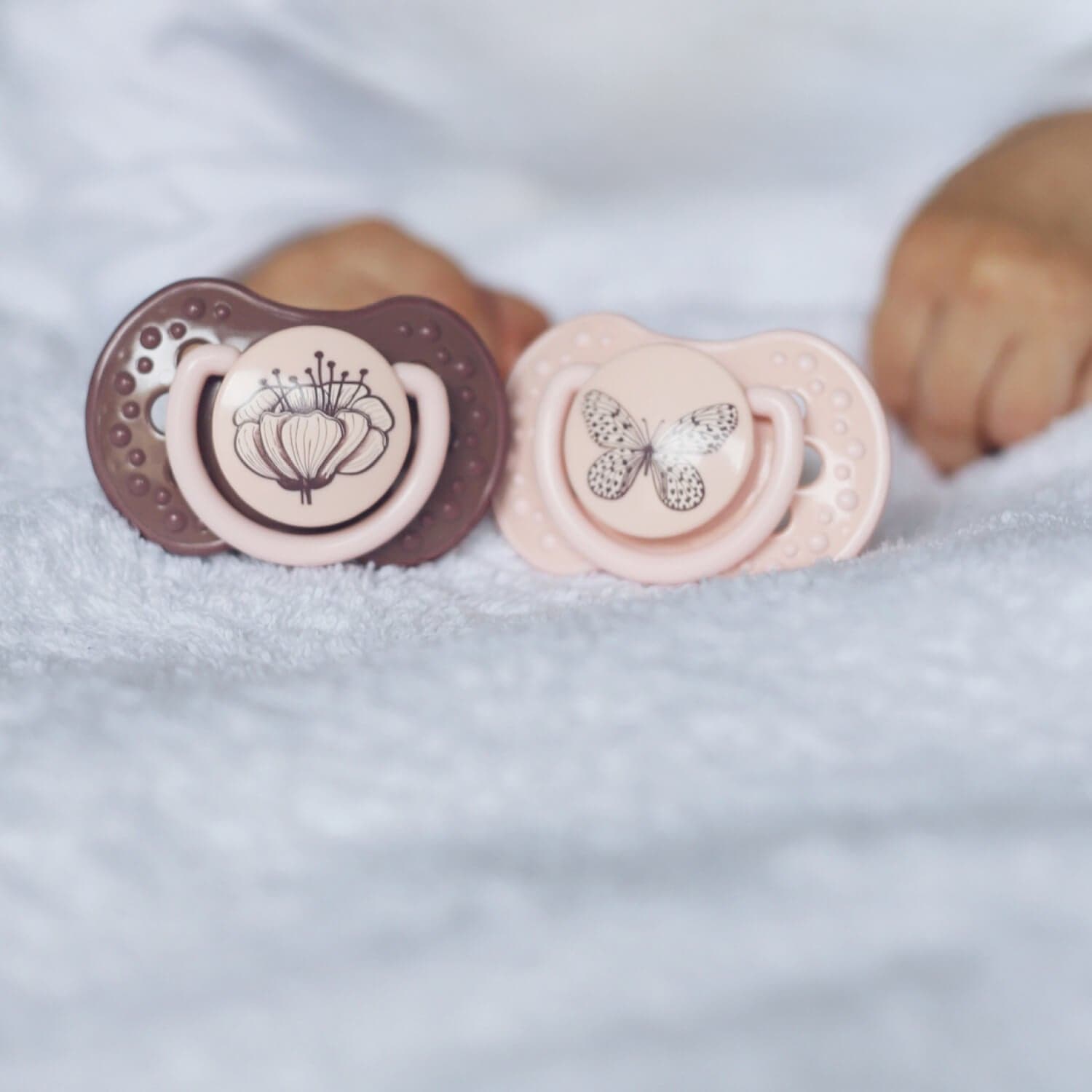 2 Sucettes dynamiques botaniques de couleur rose et violet.