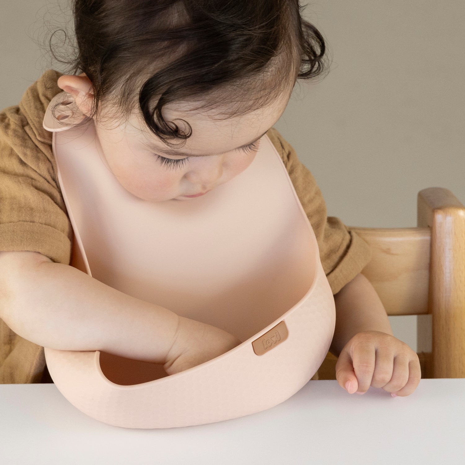 Enfant portant un bavoir de repas en couleur Nude, parfait pour les repas