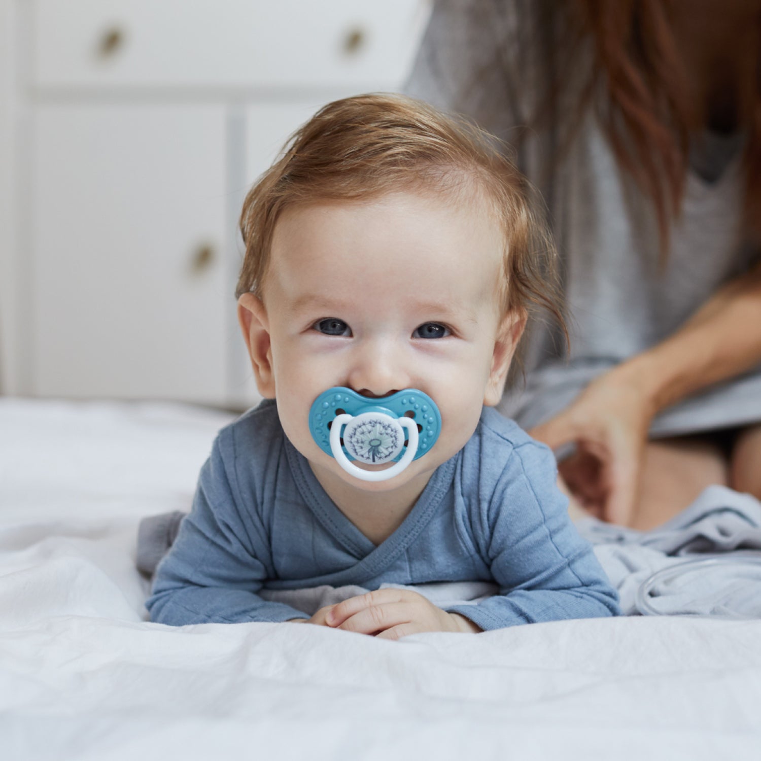 Un petit garçon heureux avec la sucette bleue.