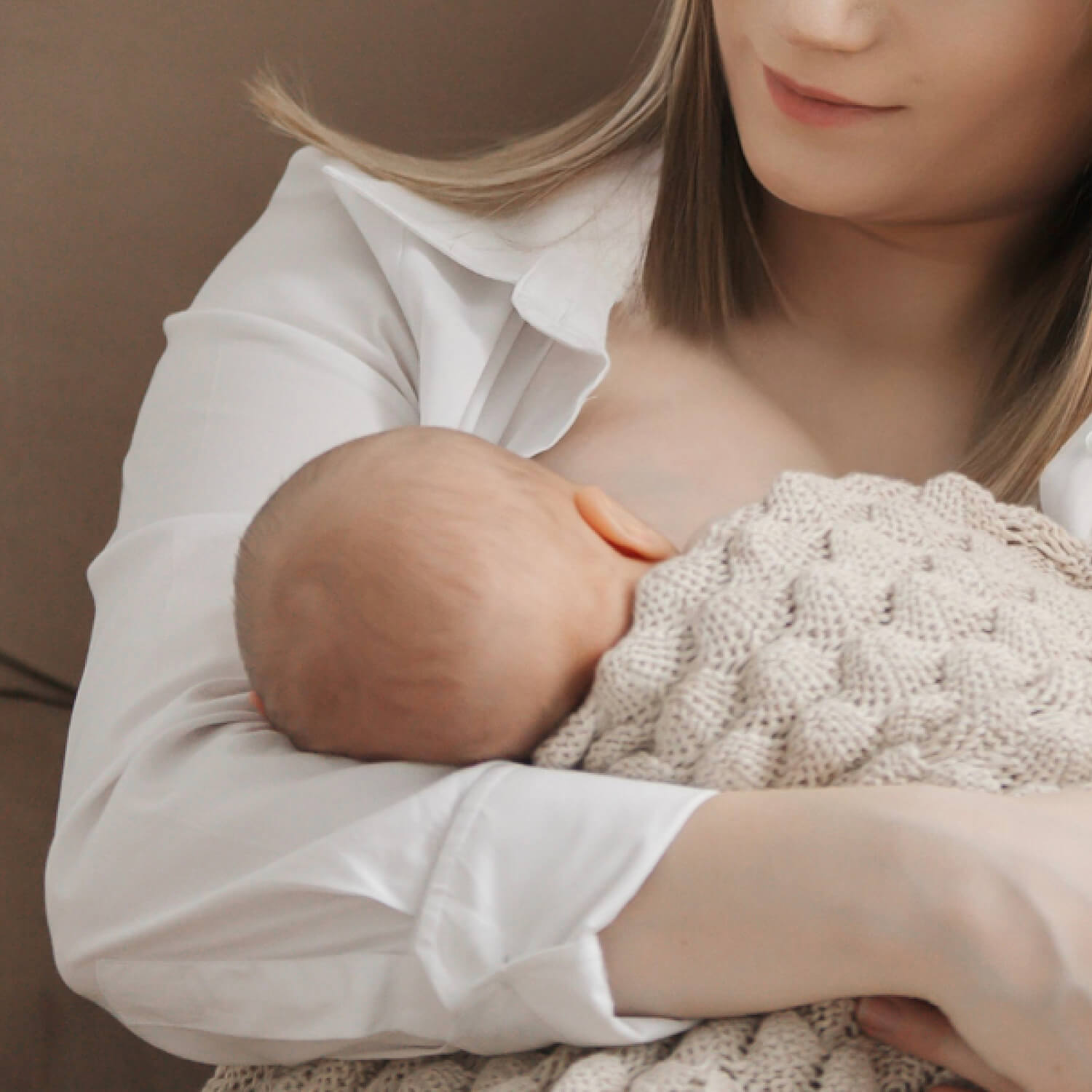 Maman donnant le sein à son bébé, utilisant des coussinets d’allaitement pour plus de confort