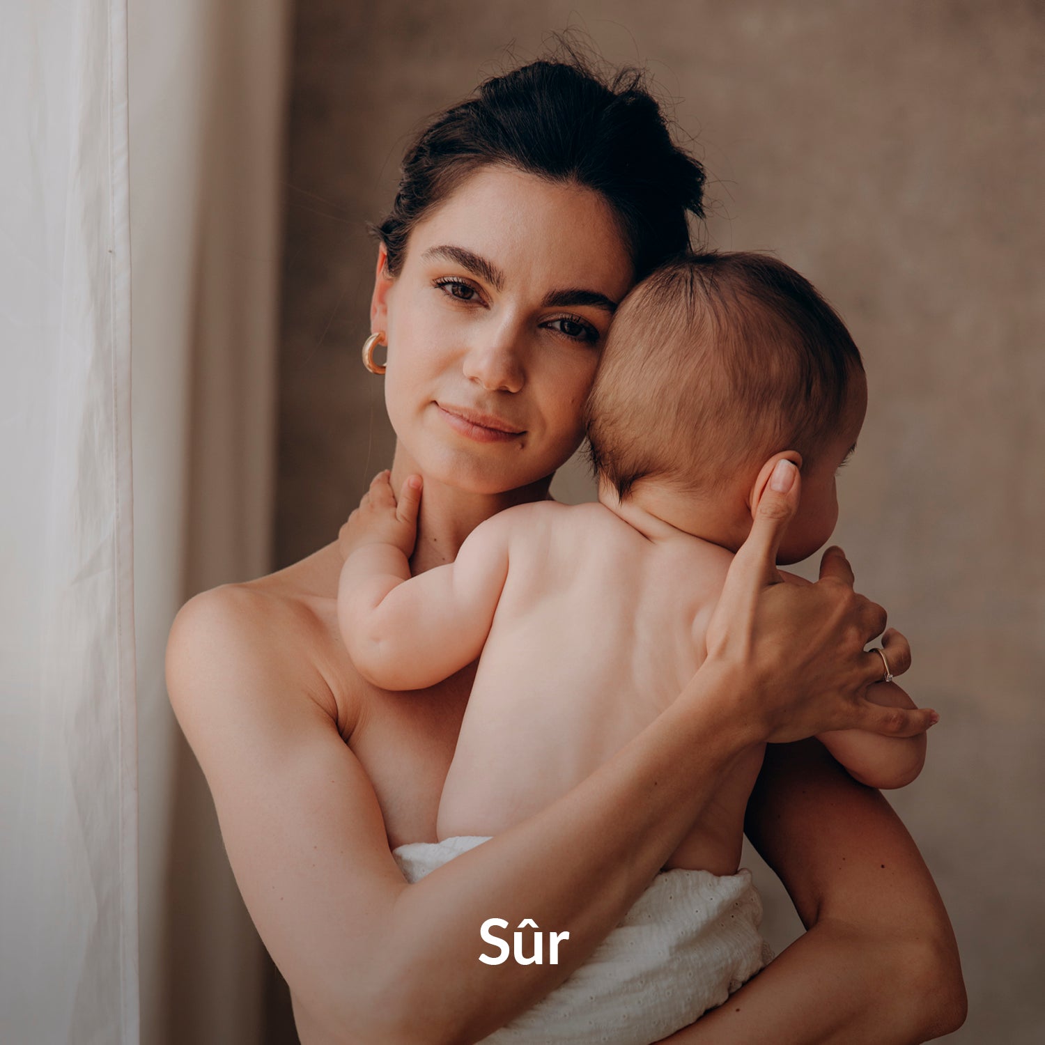 Maman tenant son bébé sur le canapé pendant que le biberon chauffe avec un chauffe-biberon