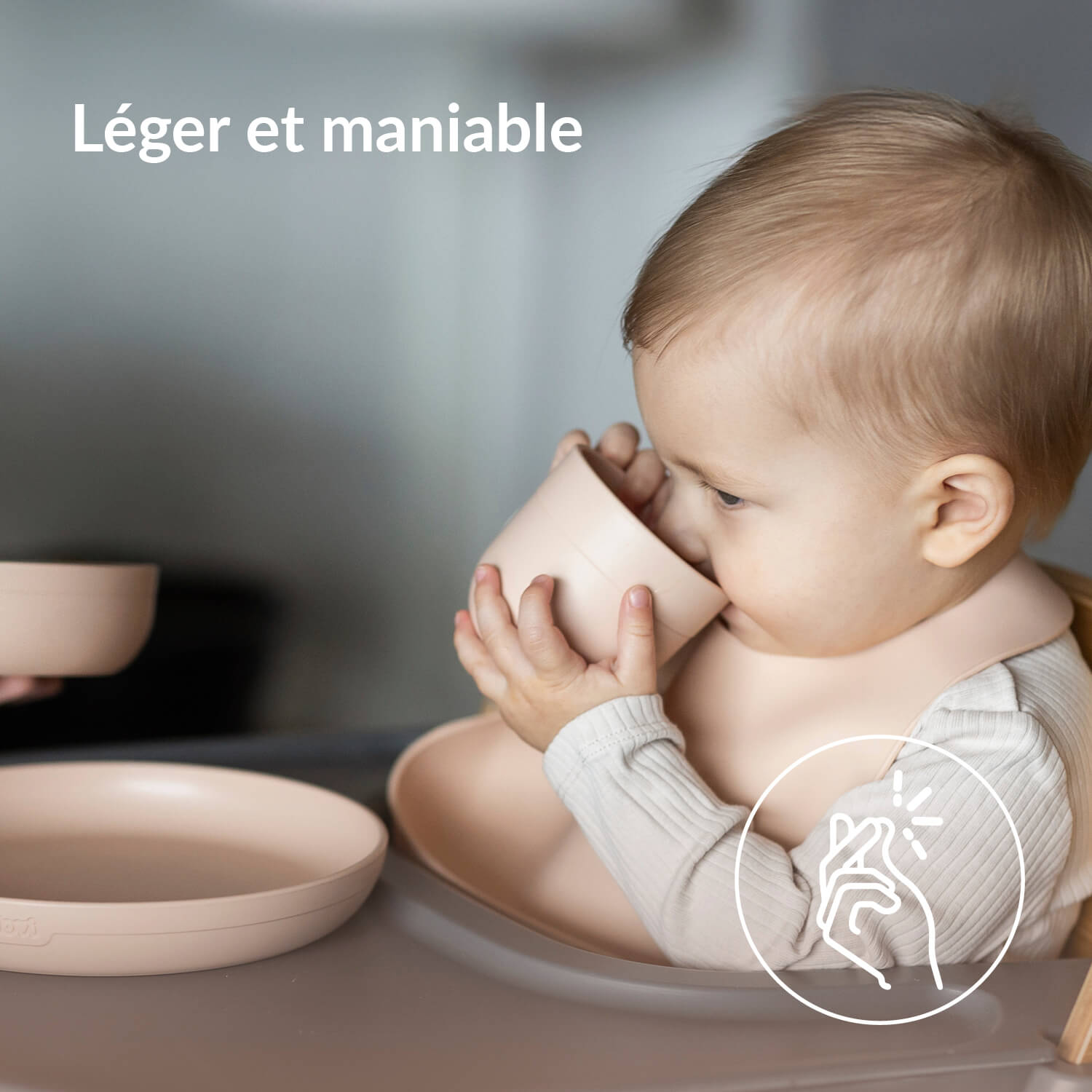Enfant dans une chaise haute buvant dans la tasse du set repas bébé en nude avec assiette et bol assortis