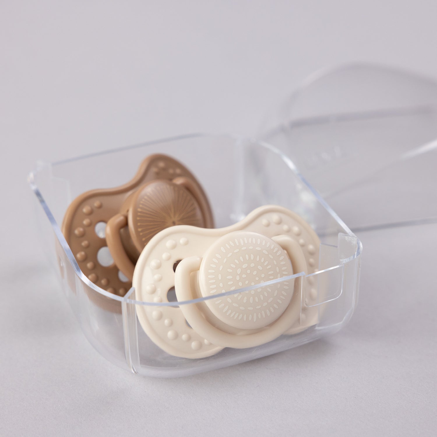 2 sucettes Harmony collection dans une boîte de rangement.