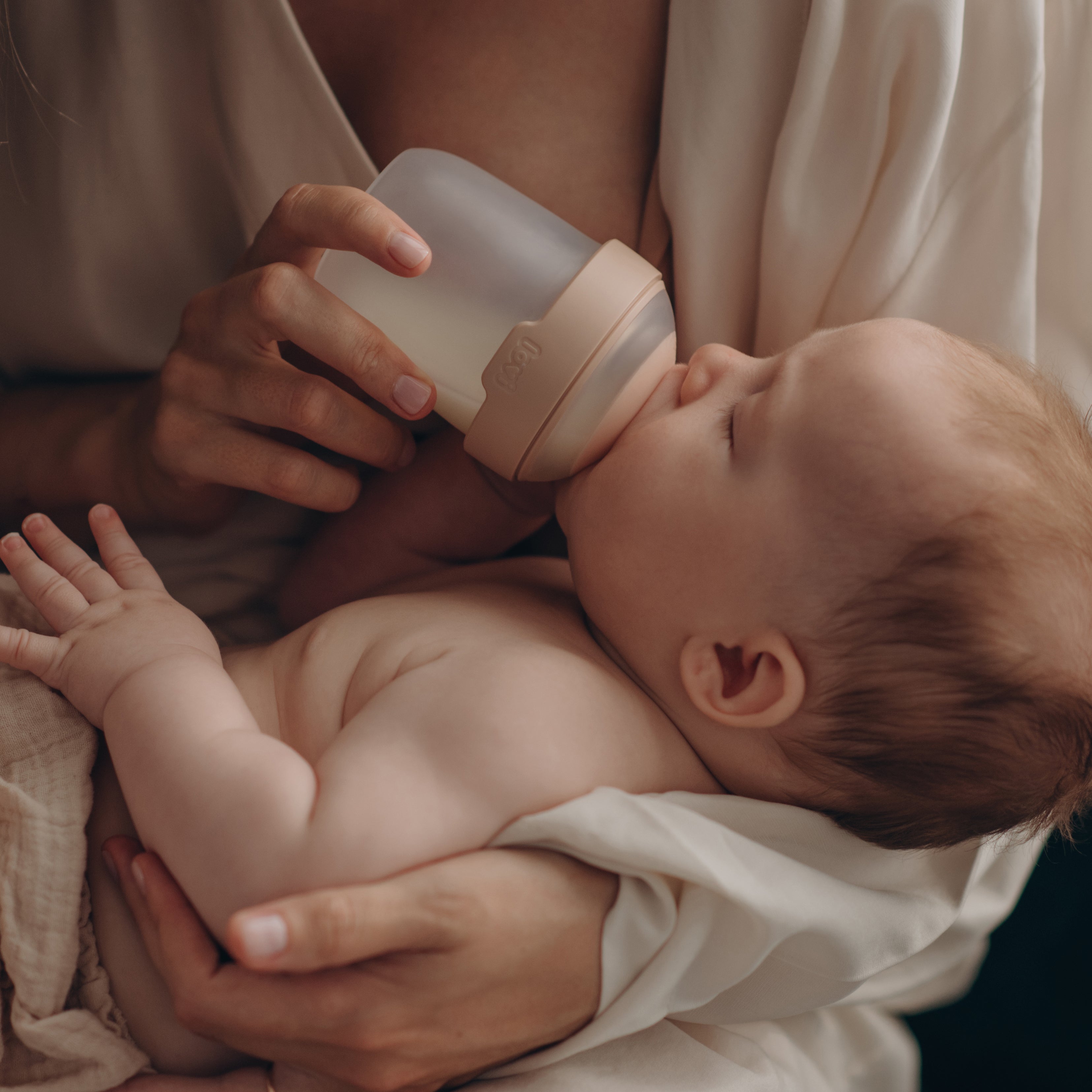 Un bébé qui boit dans un biberon Difrax LOVI