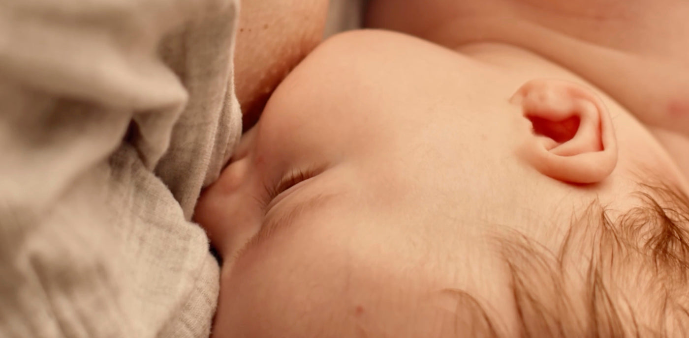 Bébé tétant au sein de sa mère, illustrant les bienfaits du colostrum pour l’immunité et la nutrition dès la naissance