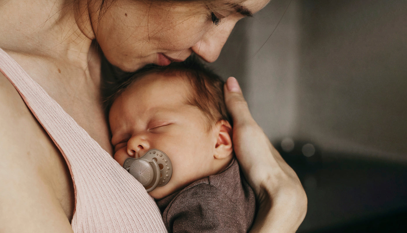 Maman embrassant tendrement son nouveau-né.