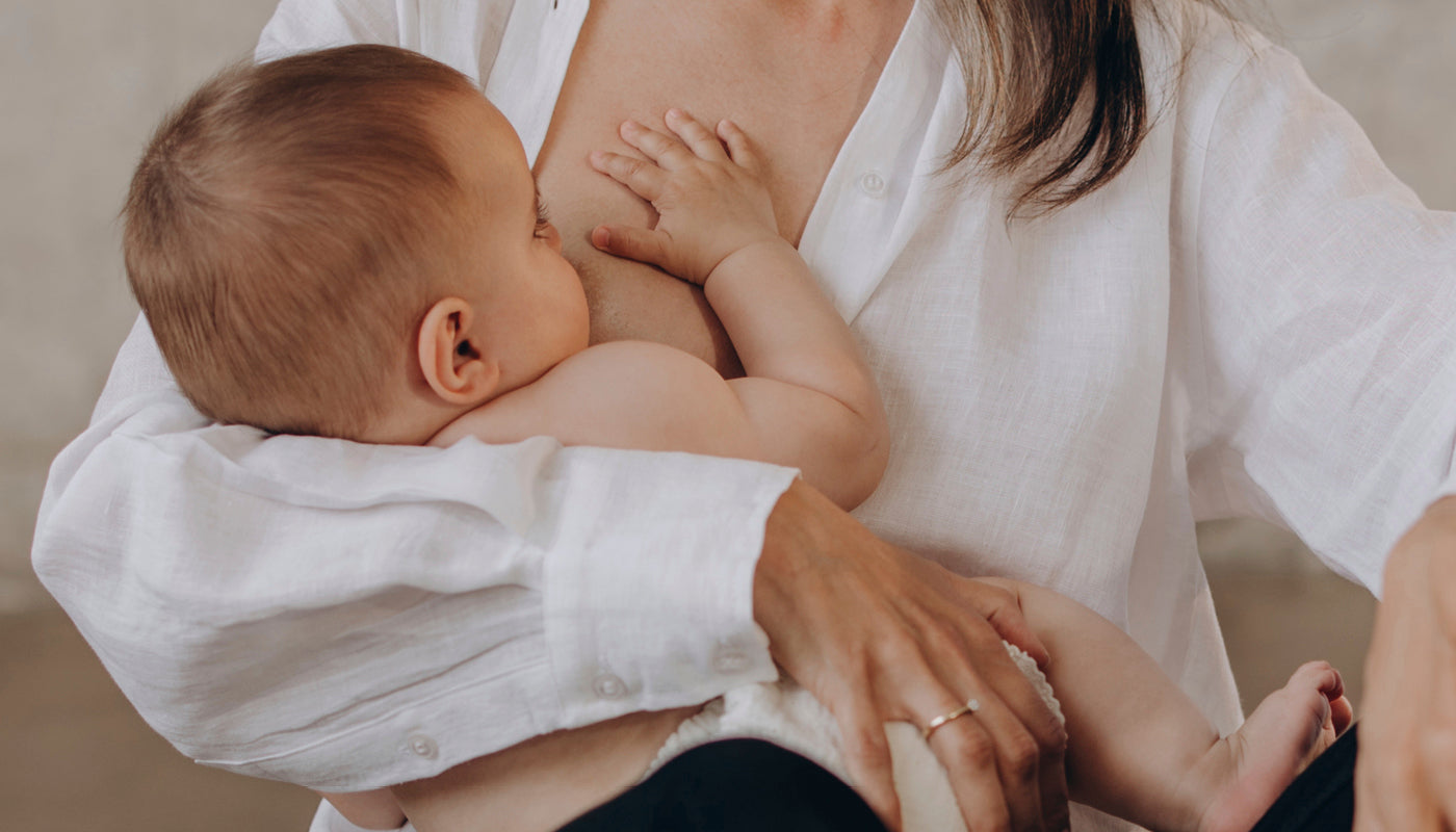 Bébé tétant au sein de sa mère, illustrant le lien affectif et l’allaitement maternel fréquent.