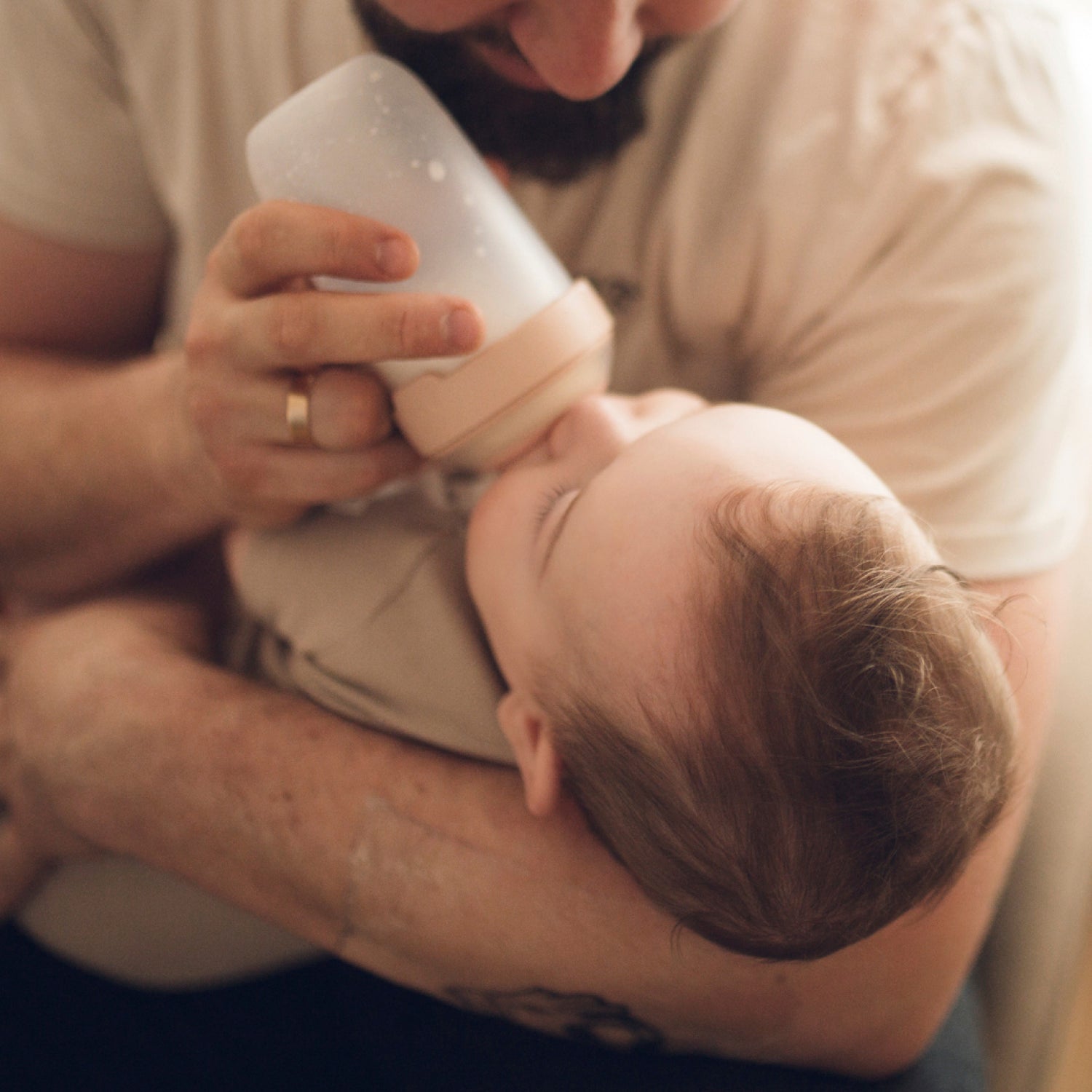 Père donnant le biberon à son bébé