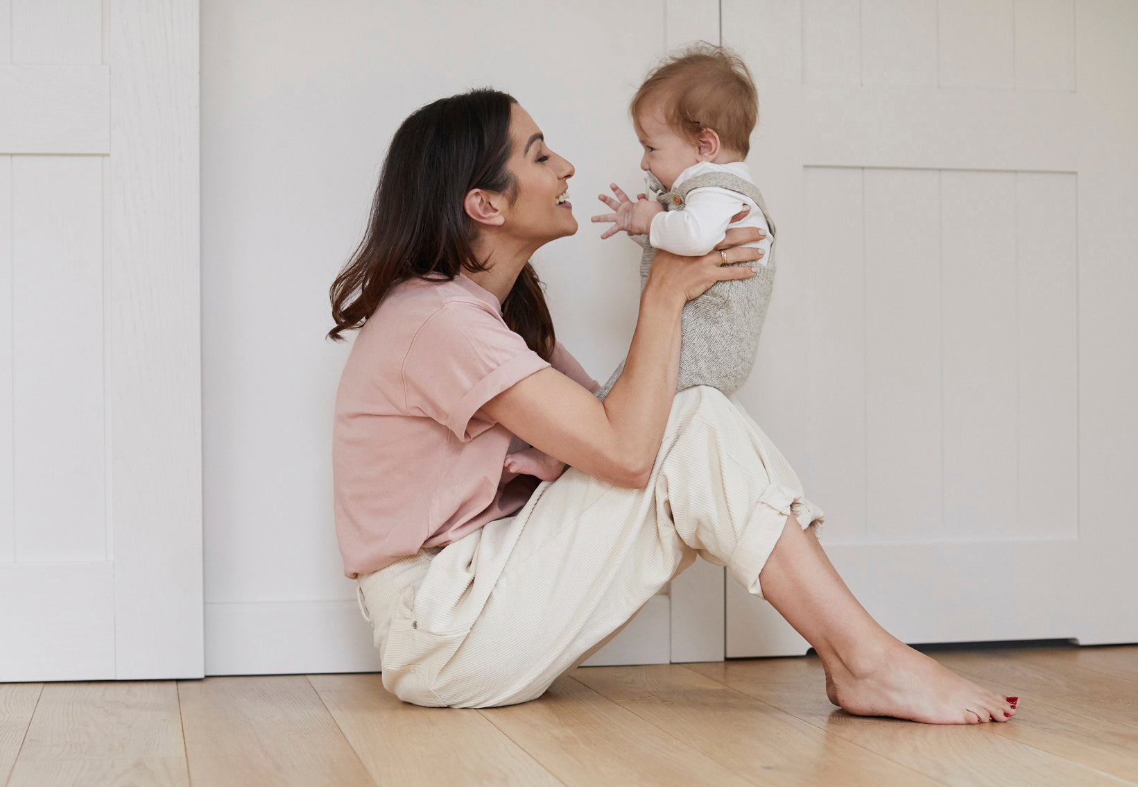"Une mère joue avec son bébé sur ses genoux.