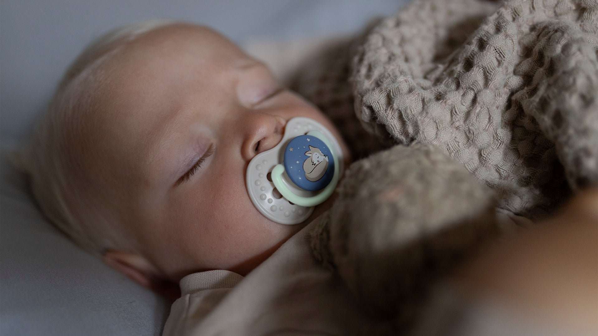 Bébé endormi avec une tétine qui brille dans le noir, idéale pour apaiser votre enfant la nuit