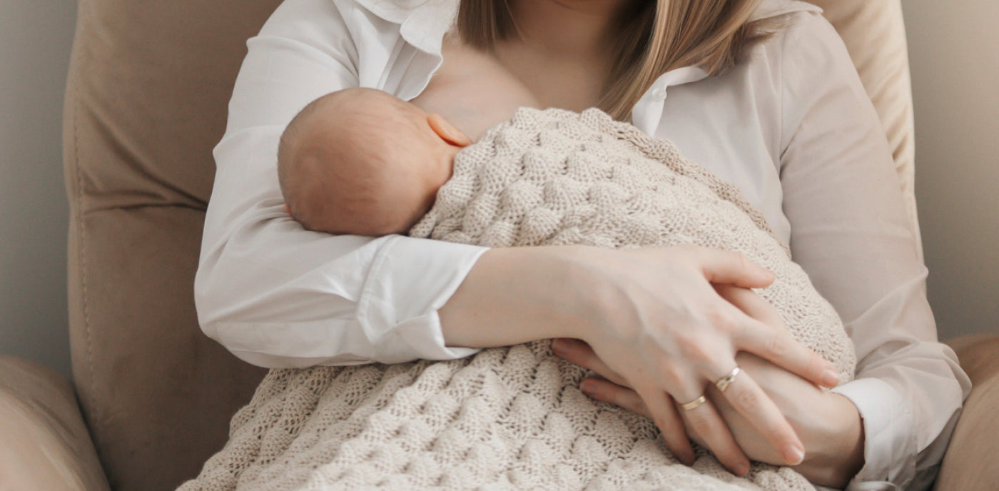 Bébé reçoit le lait maternel au sein de sa mère, illustrant l’importance de la surveillance de la prise de poids et du soutien à l’allaitement pour un développement sain.