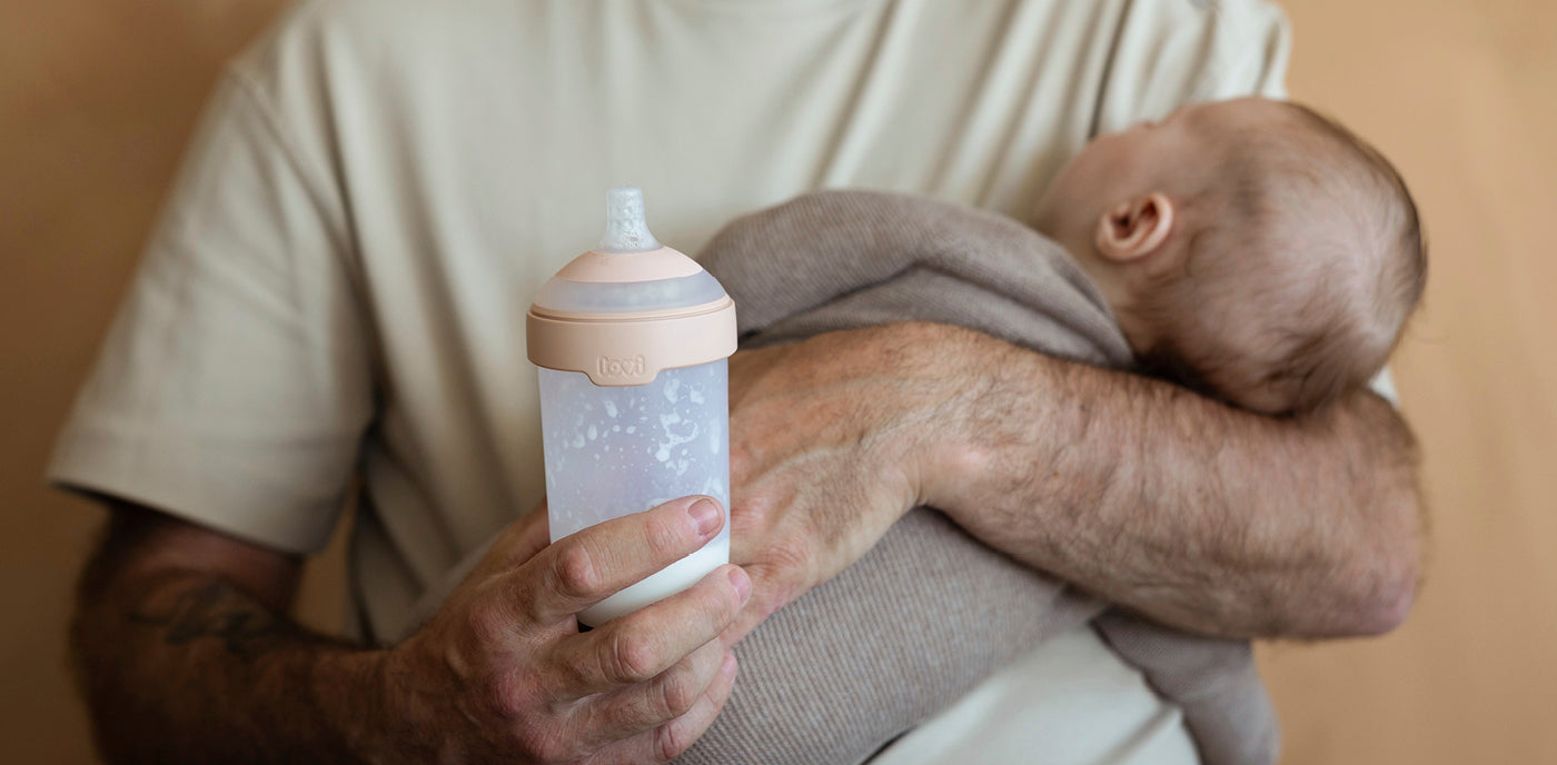 Parent tenant doucement un bébé agité et lui donnant le biberon Difrax MammaFeel pour un moment de tétée calme et confortable.