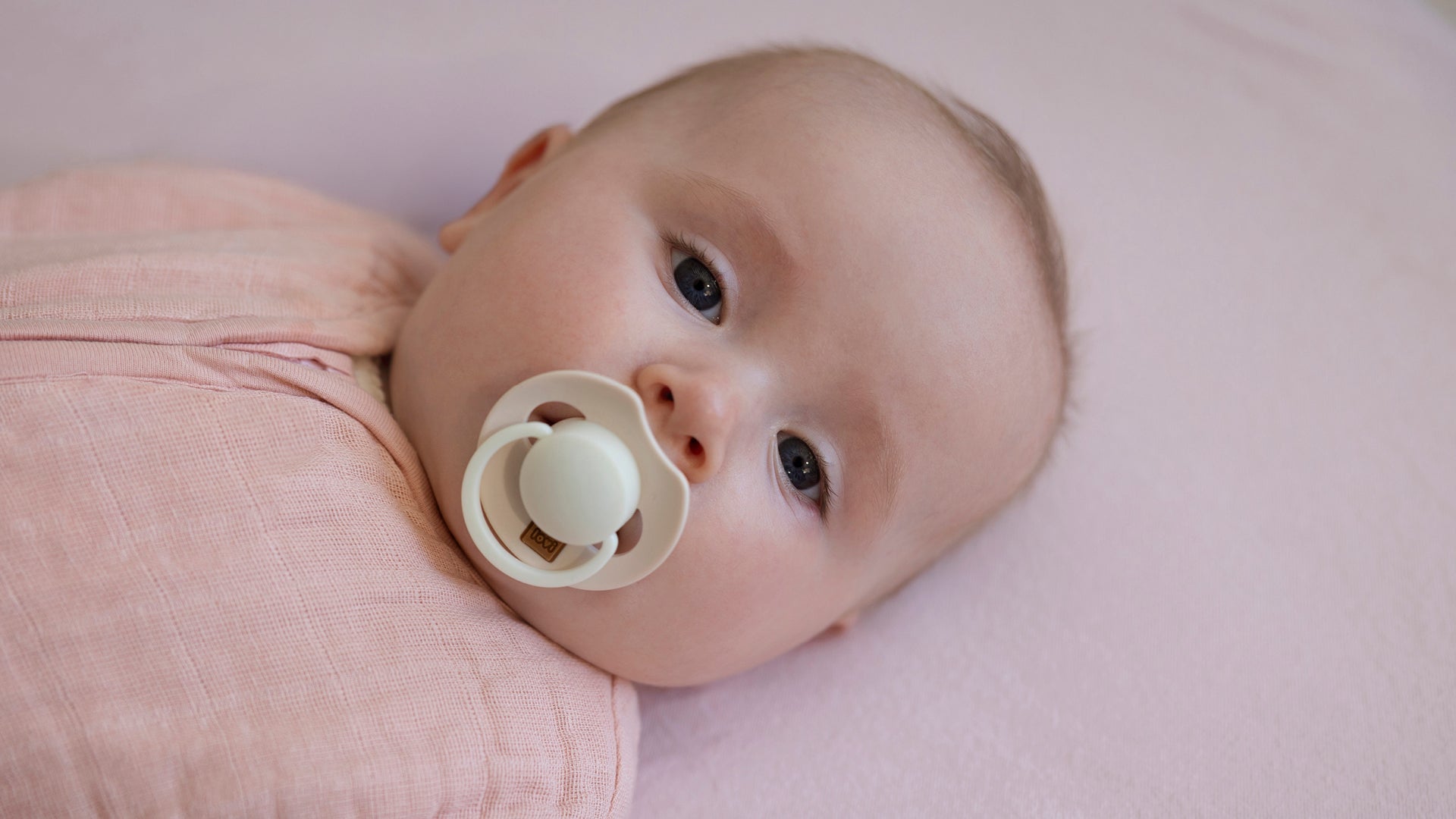 Bébé apaisé avec une sucette Prime Glow dans la bouche.