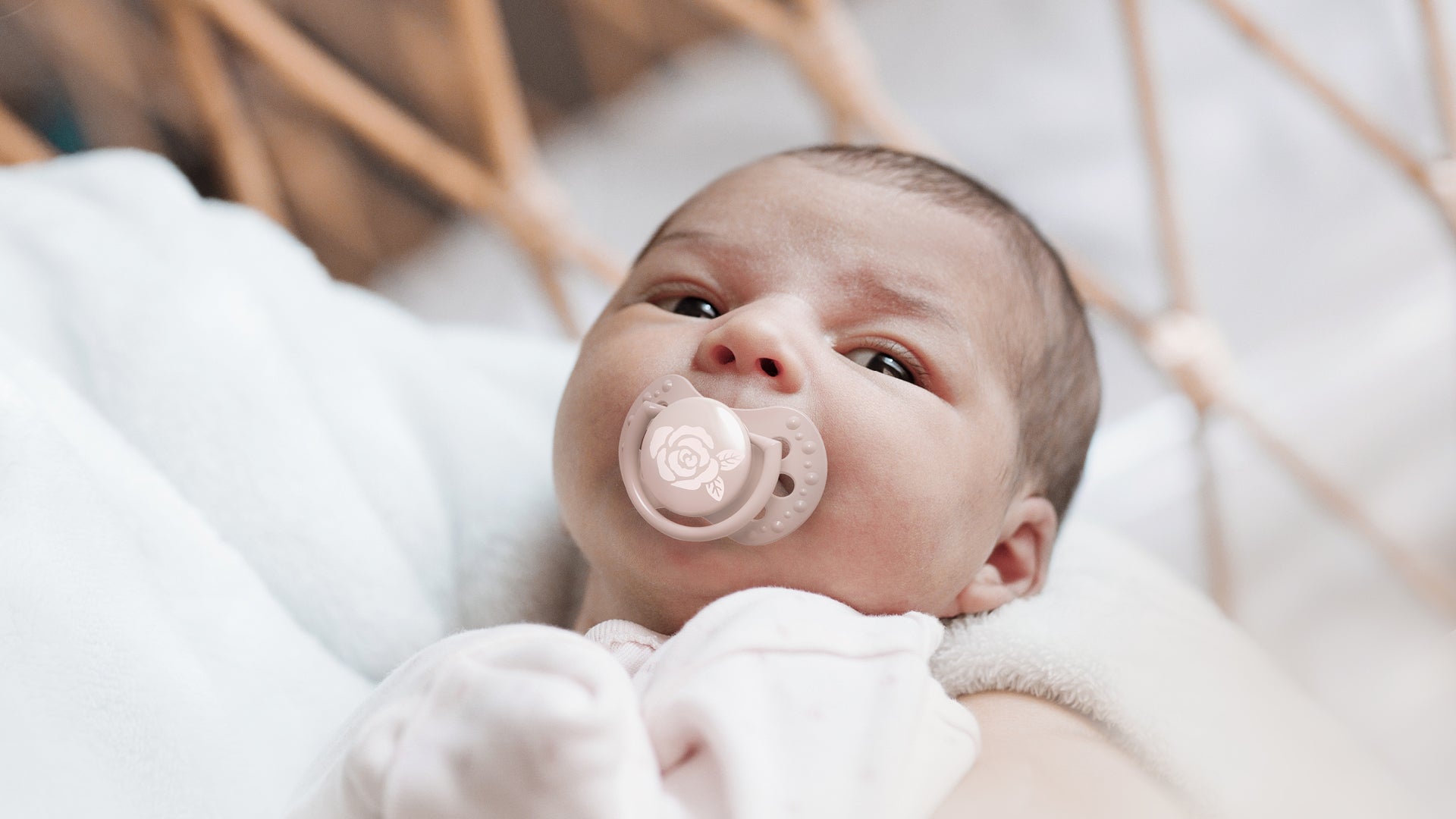 Un nouveau-né fille avec une sucette rose clair de la collection Difrax LOVI Baby Shower.