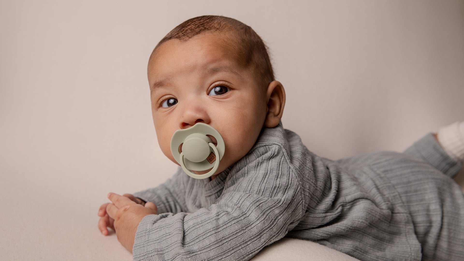 Un tout-petit avec une sucette ivoire Difrax LOVI de la collection Prime.