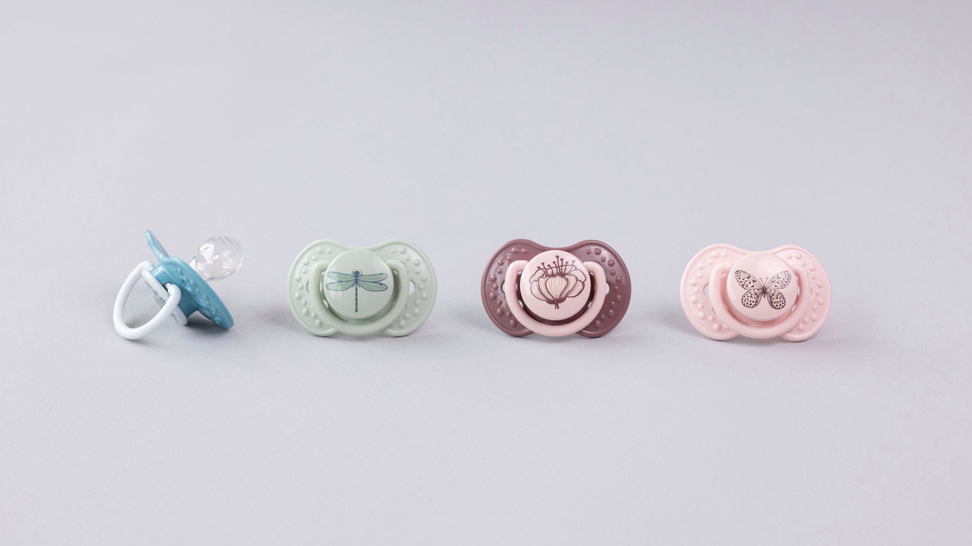 Une sucette bleue et verte sur une serviette. Les sucettes font partie de la collection Difrax LOVI Botanic.