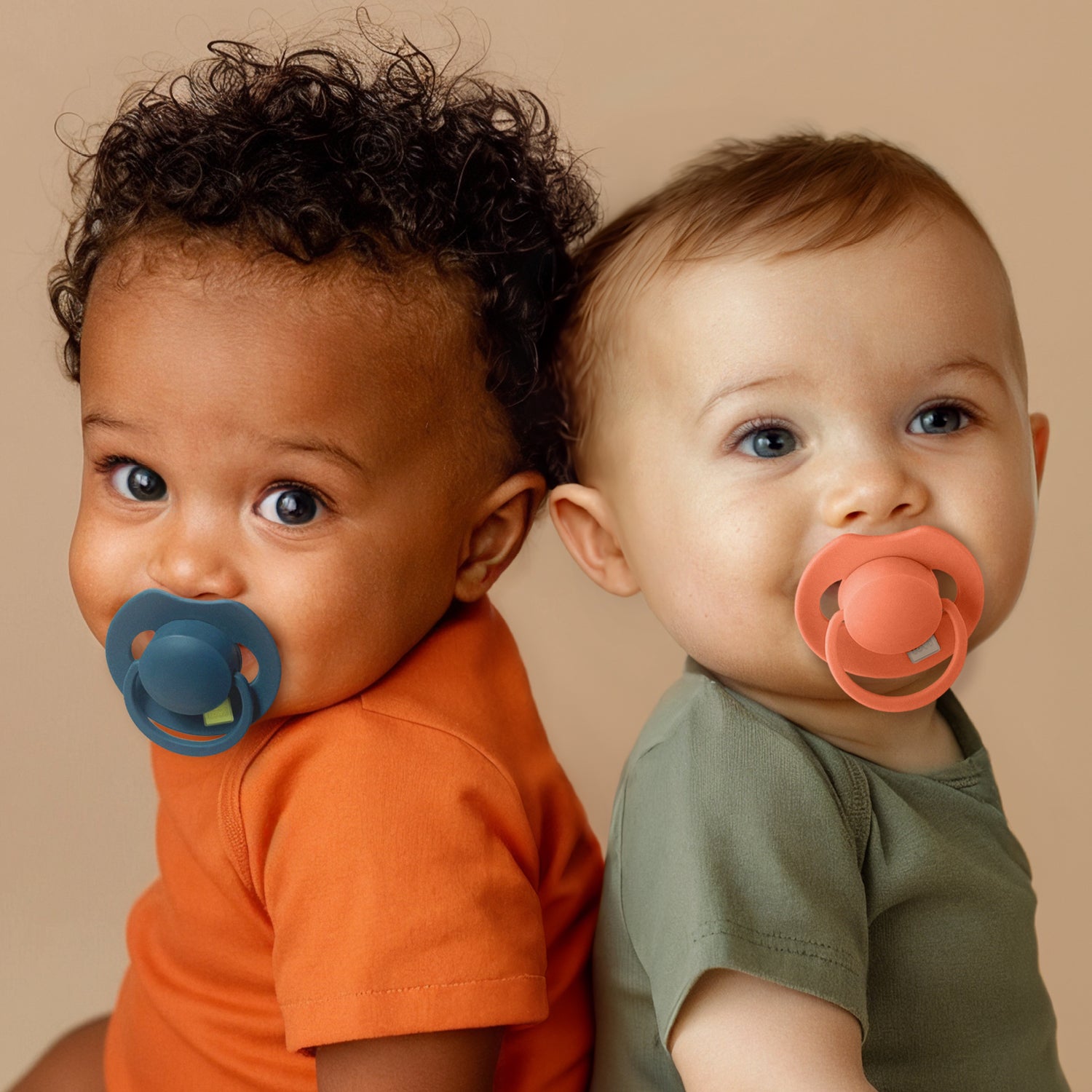 Deux enfants de 12 mois portant des tétines Prime en couleurs bleu et granola