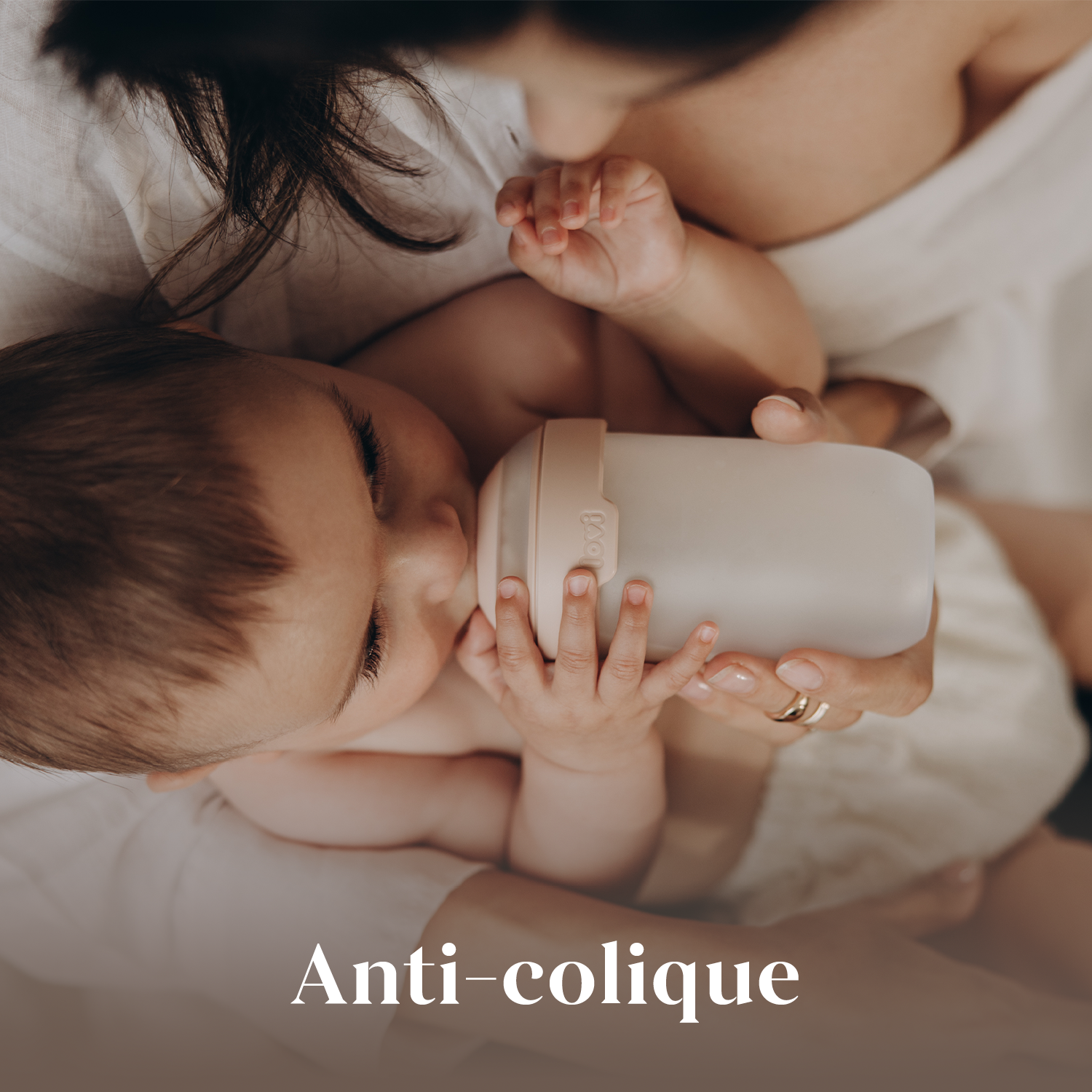 bébé boit dans un biberon anti-colique