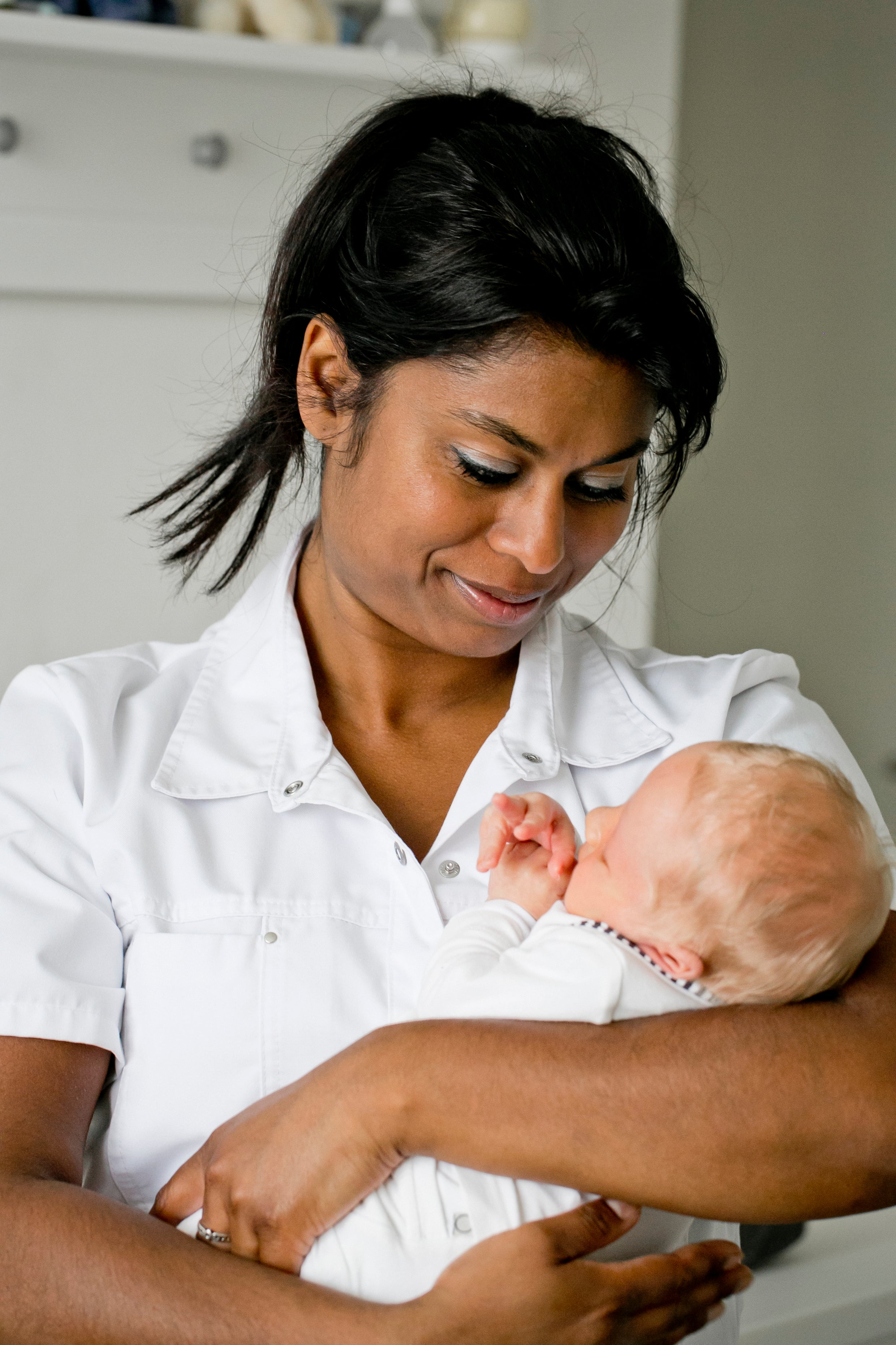 Puéricultrice tenant un nouveau-né - soins maternité professionnels à domicile