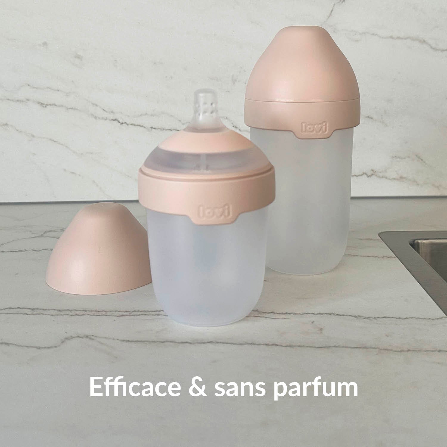 Deux biberons en silicone Lovi sur un plan de travail en marbre – nettoyés efficacement et sans parfum avec les tablettes lave-vaisselle éco-certifiées Difrax