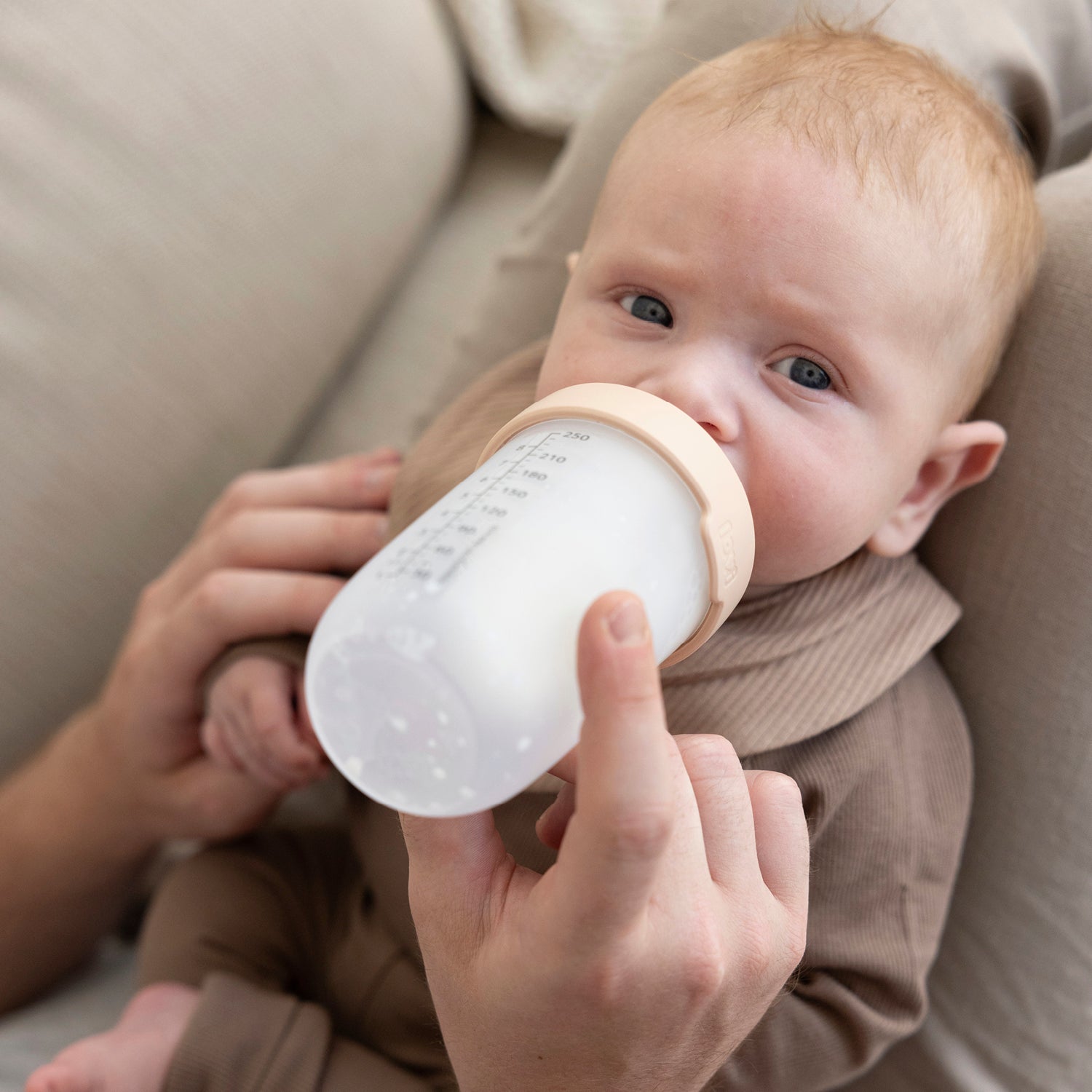Bébé nourri au biberon Mammafeel par son parent, tétine douce adaptée à l’allaitement