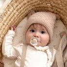Un bébé plus jeune avec 2 sucettes dynamique Prime dans les couleurs Coconut et Ivory