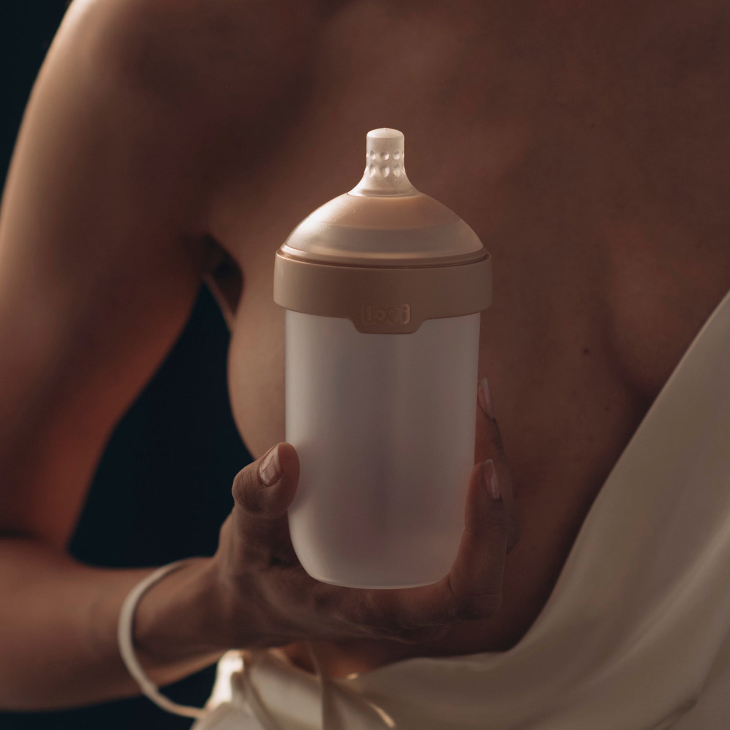 Biberon Mammafeel devant une poitrine, idéal pour l’allaitement et les bébés sensibles