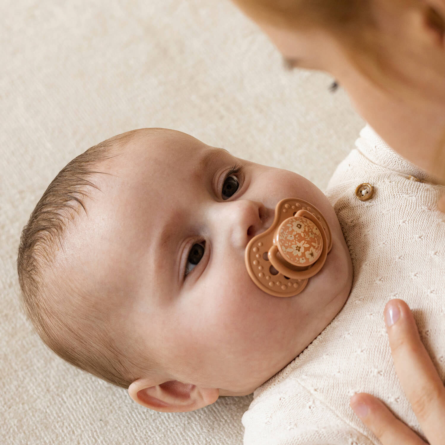 Bébé couché avec la sucette Difrax LOVI Blossom Girl Nouveau-né 0-6 mois dans la bouche, regarde sa mère, silicone, petit bouclier, anneau phosphorescent, sans BPA
