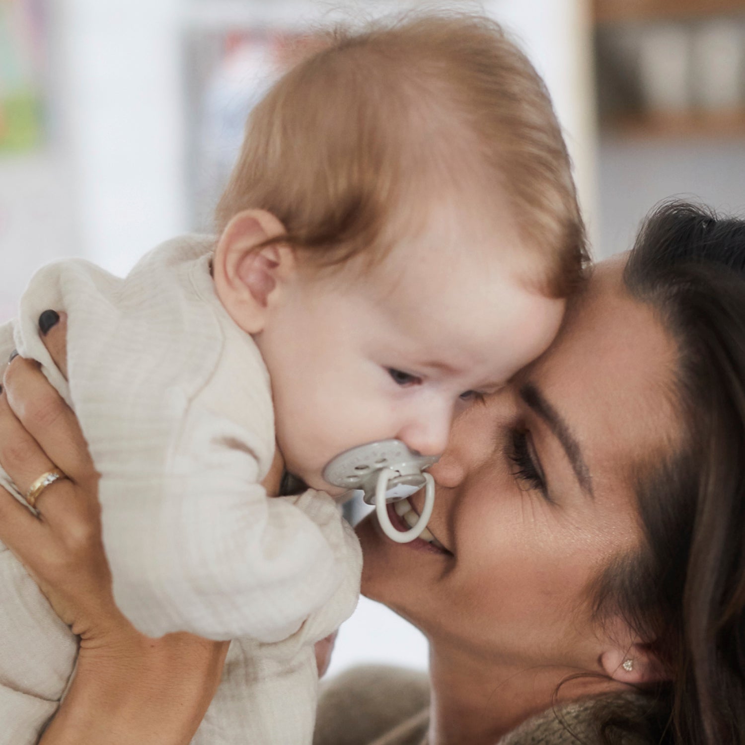 Mère tenant et câlinant son bébé avec la sucette Difrax LOVI Buddy Bear Nouveau-né 0-2 mois en silicone, petit bouclier, anneau phosphorescent
