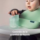 Enfant à la table à manger avec le gobelet d’apprentissage Difrax LOVI Genius, montrant la fonction de contrôle de la quantité de liquide