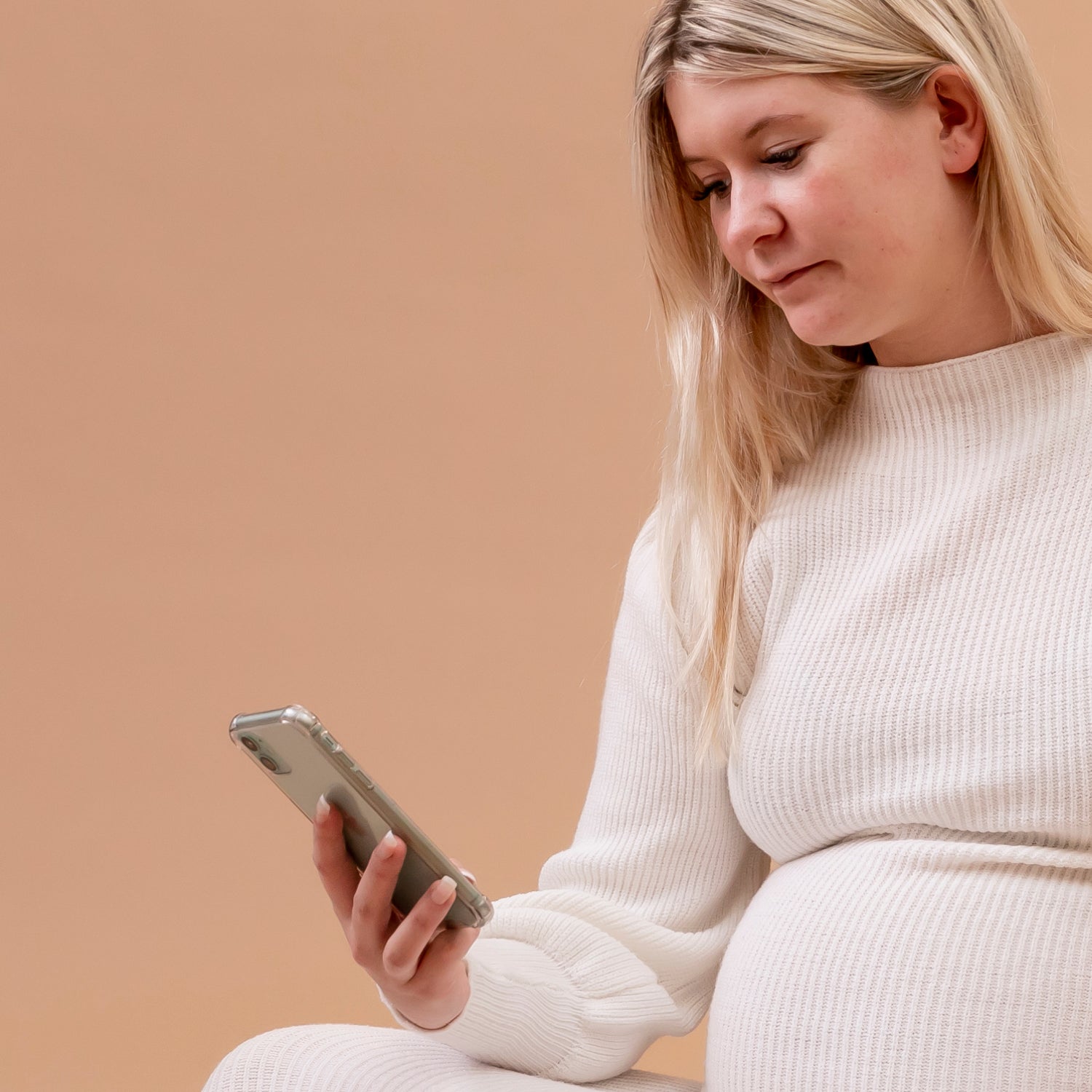 Femme enceinte 36 semaines consultant son smartphone - application grossesse et suivi prénatal