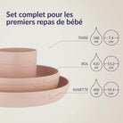 Set repas et boissons pour bébé Nude avec assiette 400 ml (Ø 19,1 cm), bol 420 ml (Ø 15,2 cm) et tasse 180 ml (Ø 7,4 cm), incluant cuillères et bavoir en silicone, idéal pour les premiers repas de bébé.