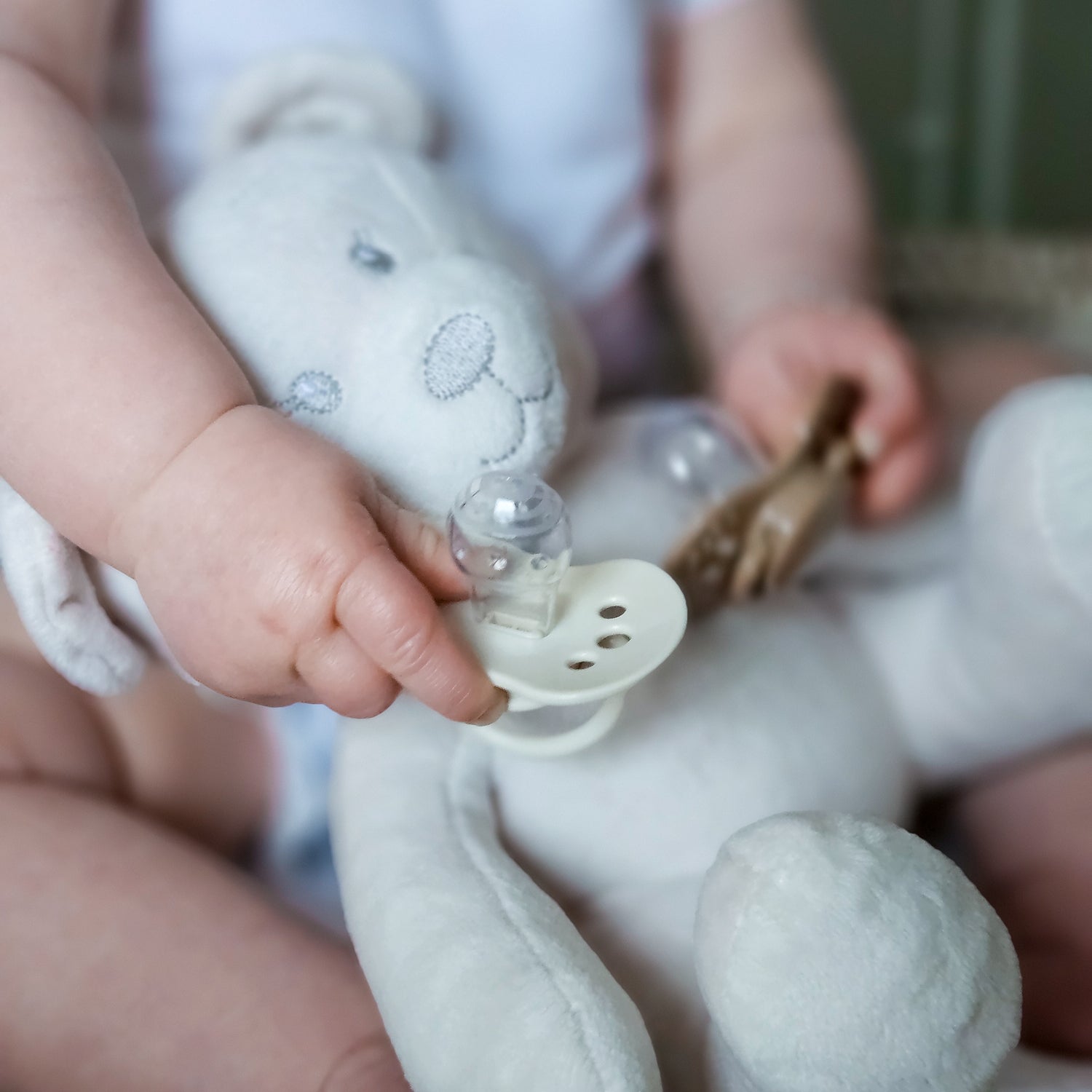 un bébé tient la sucette dynamique crème